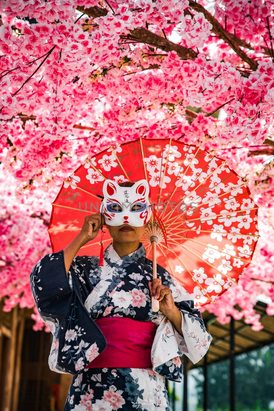 Asian girl in kimono and umbrella in Japanese theme park Hinoki Land in Chai Prakan District, Chiang Mai