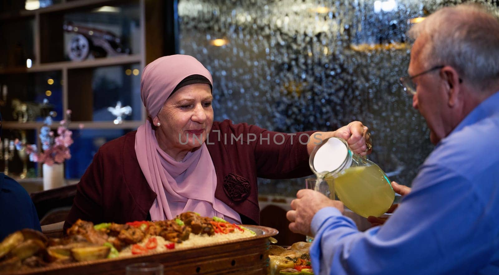 In a modern restaurant setting, an elderly Islamic European couple shares a meal for iftar during the holy month of Ramadan, epitomizing unity, companionship, and cultural tradition in their dining experience.