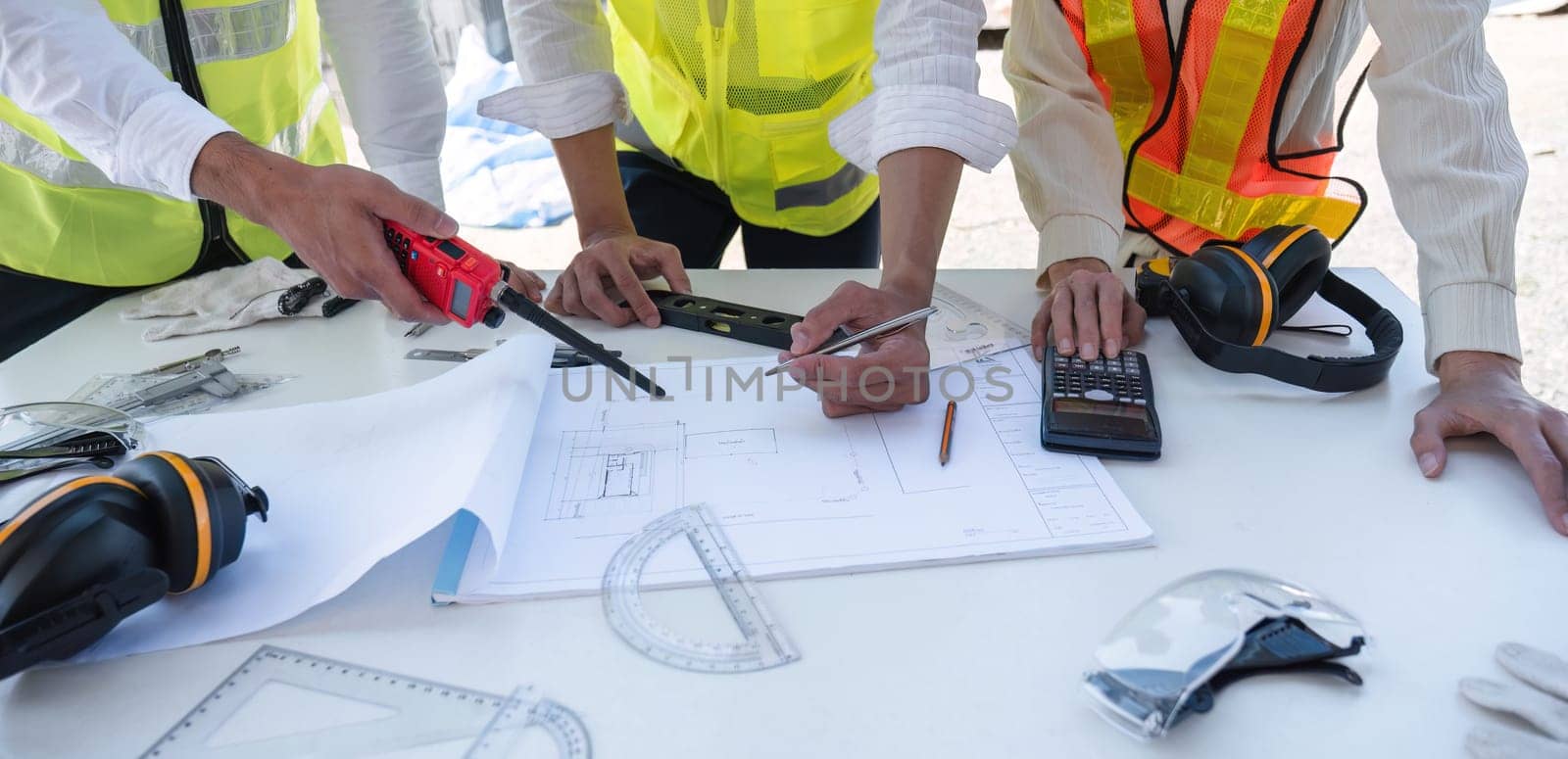 Civil engineering team meets to plan work on construction project in the construction area Foreman, industrial project manager, engineer working as a team Professional team in Asian industry by wichayada
