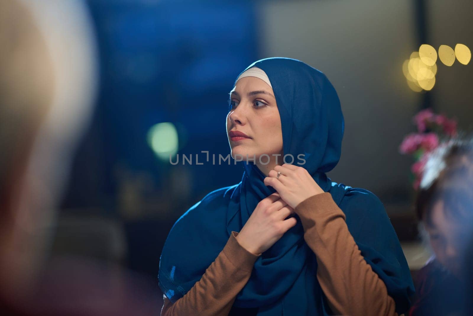 In a modern restaurant, a beautiful European Muslim woman gracefully enjoys the ambiance and culinary delights during the holy month of Ramadan, embodying elegance and spiritual serenity amidst cultural celebration.