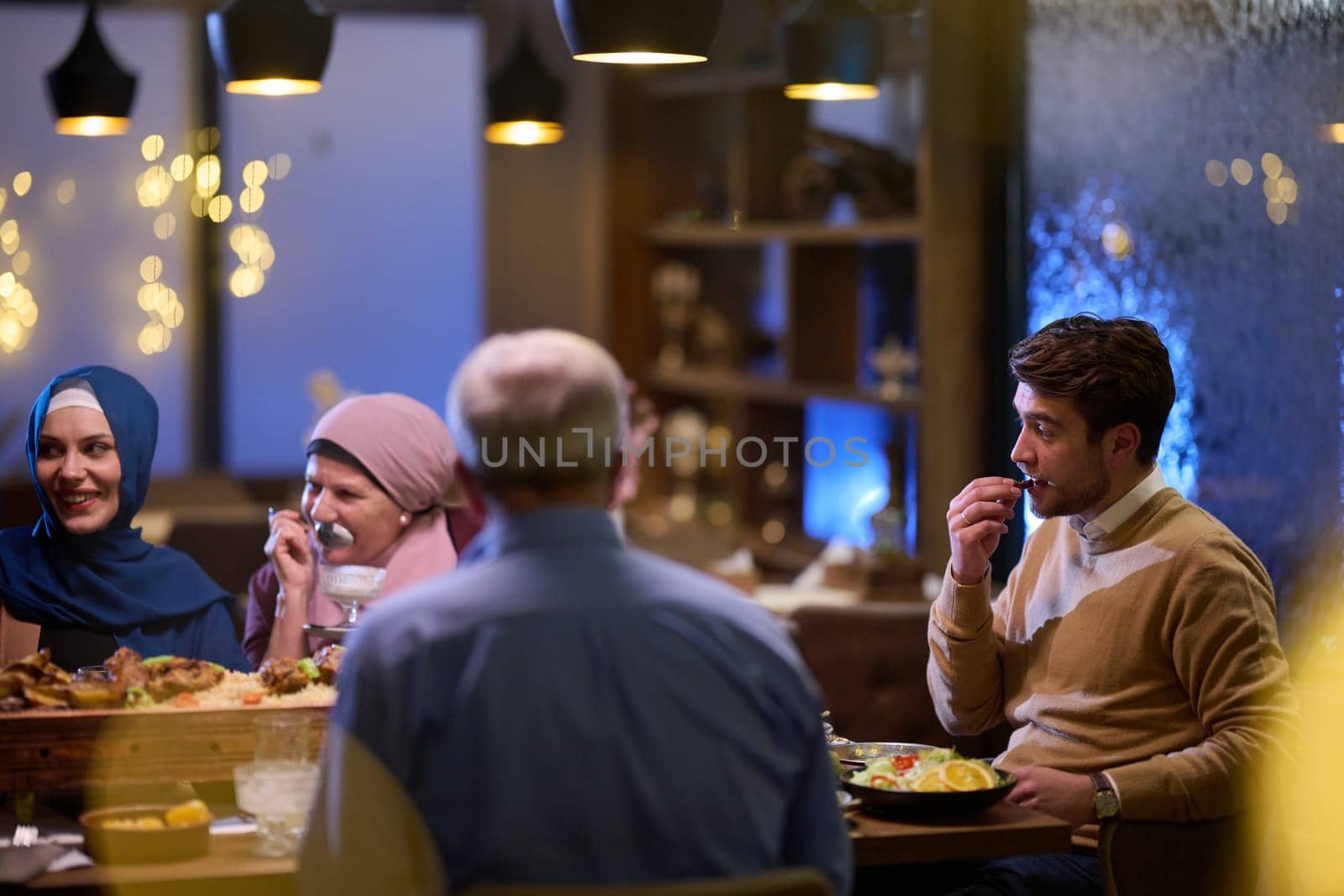 A modern and traditional European Islamic family comes together for iftar in a contemporary restaurant during the Ramadan fasting period, embodying cultural harmony and familial unity amidst a culinary celebration of diversity.