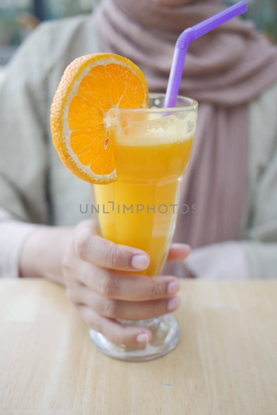 holding a glass of orange juice close up ,