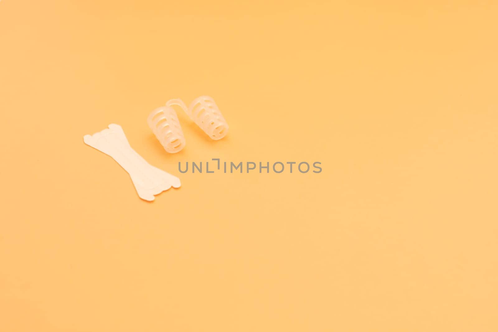 Mockup Anti Snoring Device. Nose Relief Nasal Dilator and White Nasal Strip on Peach Yellow Background, Sleeping Apnea Solution for Nasal Breathers, Snoring Problem. Space For Text Horizontal Plane. by netatsi