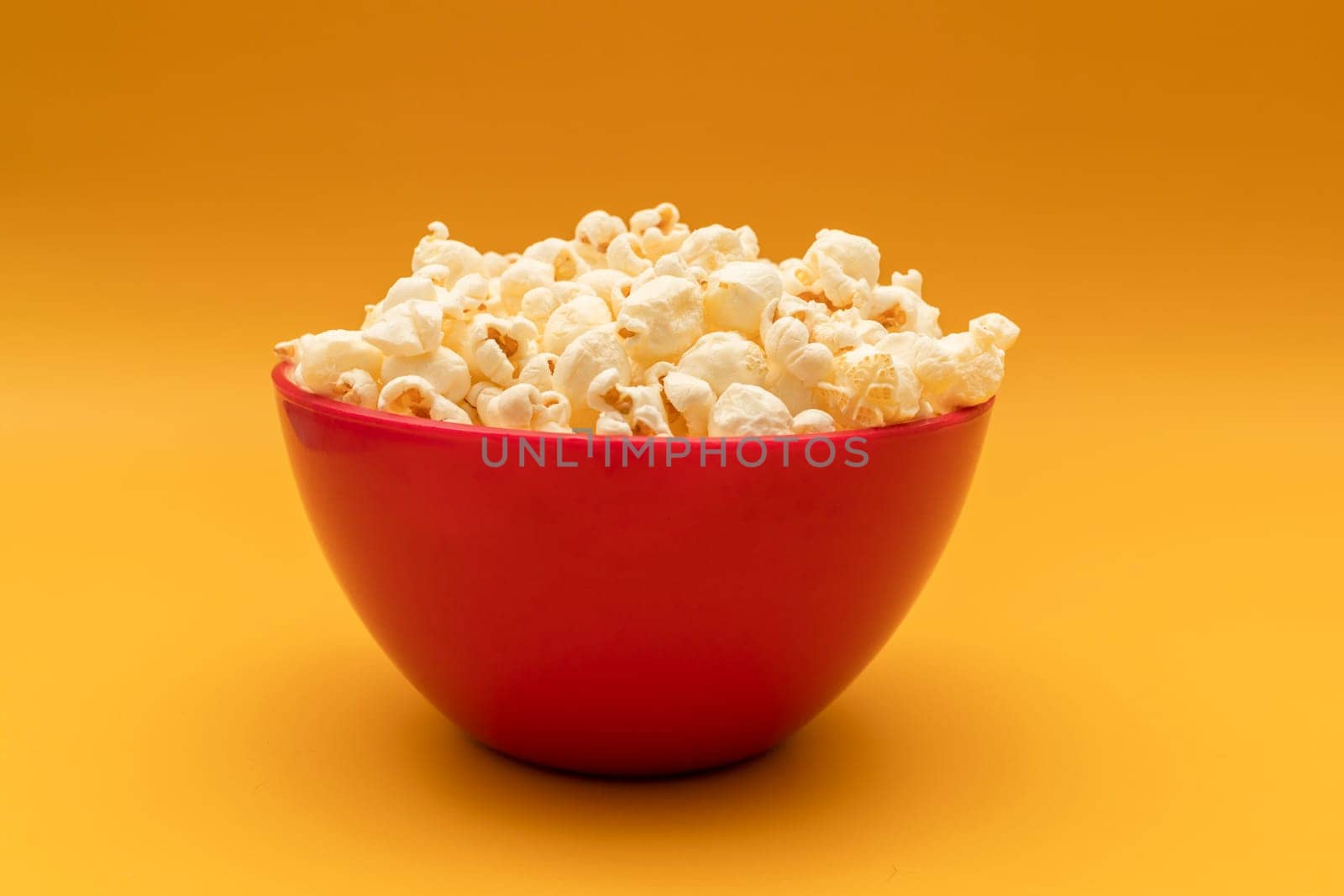 National Popcorn Lover's Day. Popcorn in Red Bowl on Yellow Background. Movie, Cinema. Greeting Card. Tasty salted Snack Flat Lay, Horizontal by netatsi