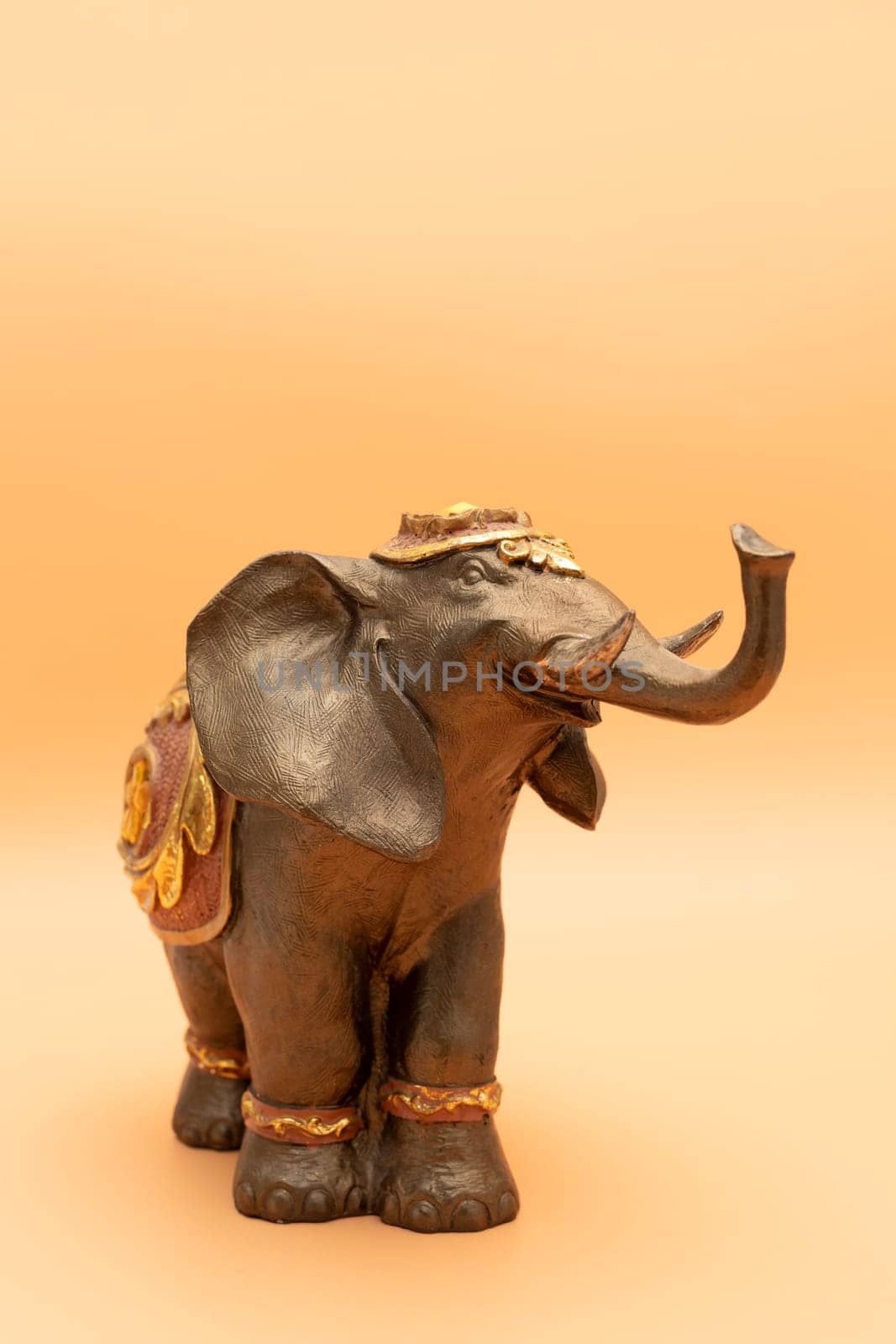 Template World Elephant Day. Bronze Decorated Elephant On Peach Yellow Background. Copy Space For Text. Ganesha Chaturthi Holiday. Sacred Symbol In Hindu, Buddhist Religions. Design, Vertical Plane