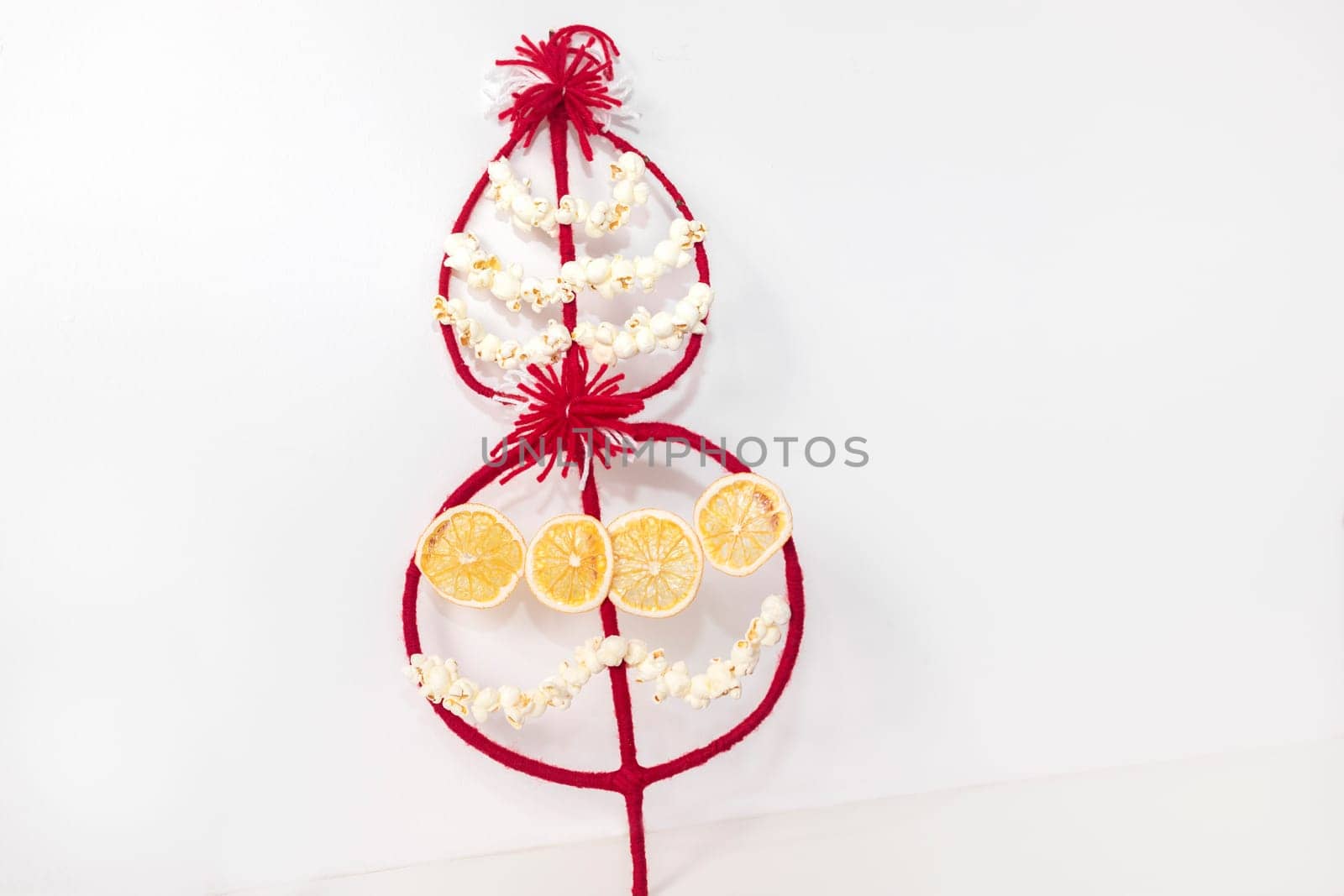 Survakane, Survaknitsa, Survachka On White Background, Surva. Bulgarian Traditional Christmas Cornel Tree Twig. Flat lay with Popcorn, Red White Threads, Dried Orange. World Tree. Horizontal plane.