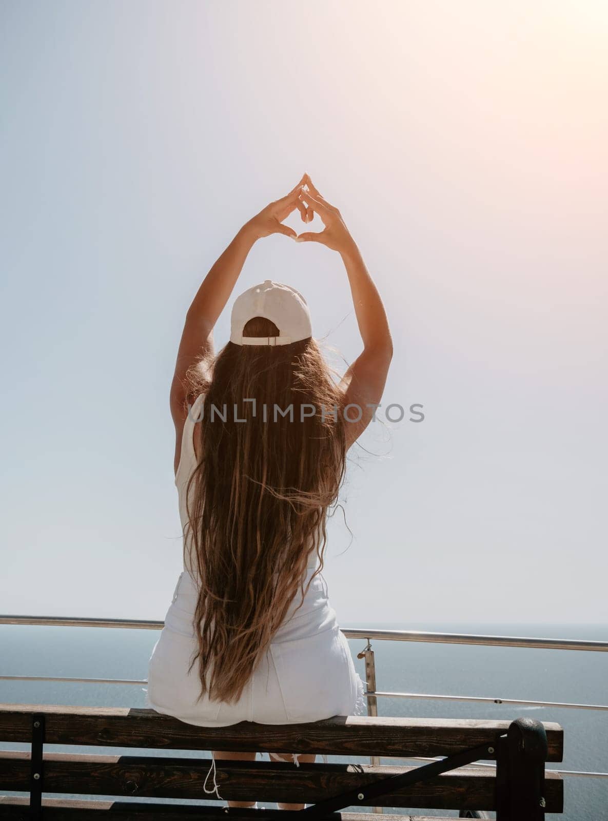 Woman travel sea. Young Happy woman in a long red dress posing on a beach near the sea on background of volcanic rocks, like in Iceland, sharing travel adventure journey