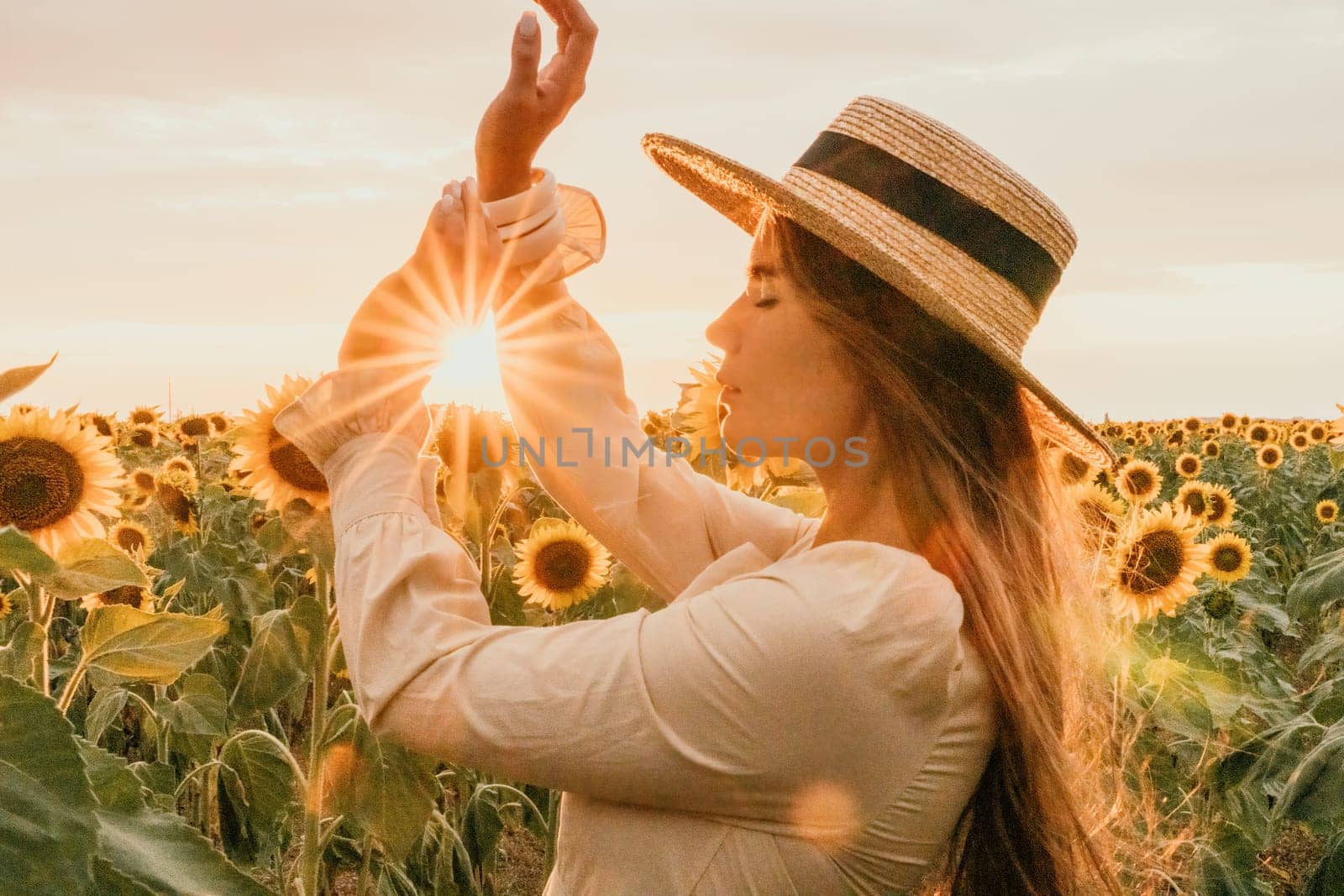 Woman in the sunflowers field. Summer time. Young beautiful woman standing in sunflower field.