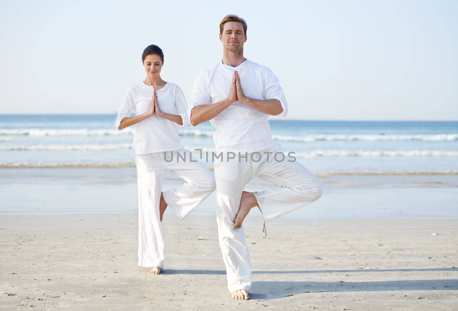 Couple, yoga and balance, meditation on beach for zen and wellness, travel and mindfulness with holistic healing. People outdoor, exercise and peace, workout together for bonding with sea and nature.