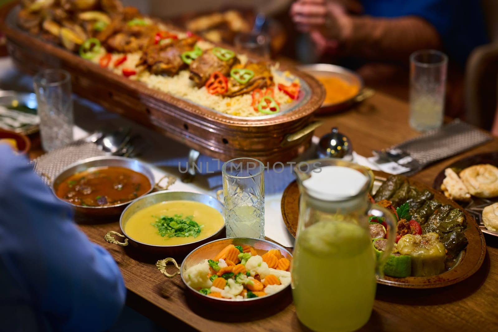 In this captivating aerial view, delicious food adorned with Ramadan decorations, including dates and meat, awaits the arrival of an European Islamic family, promising a festive and flavorful iftar celebration.