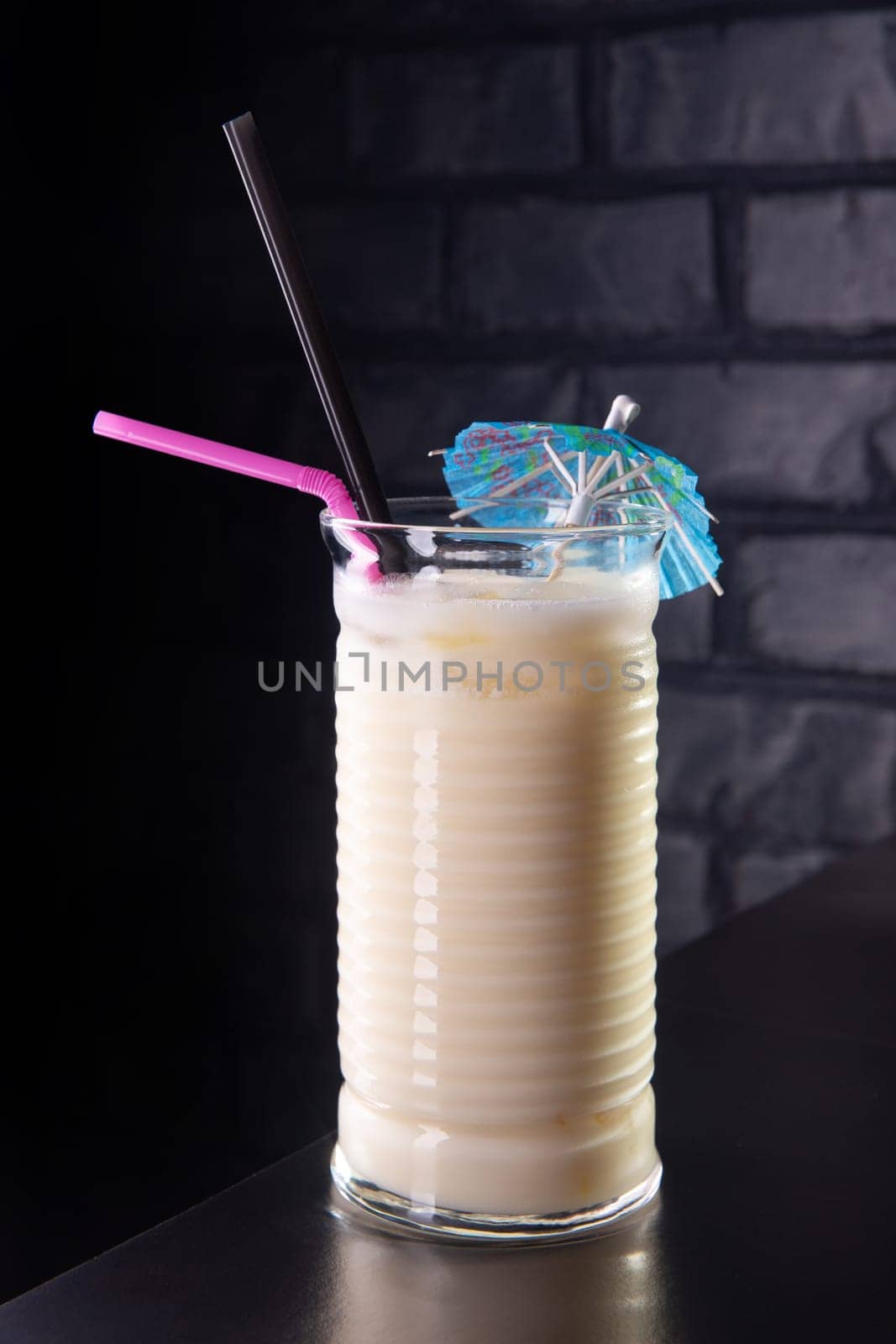 Close up of glass with white cocktail and straw by BY-_-BY