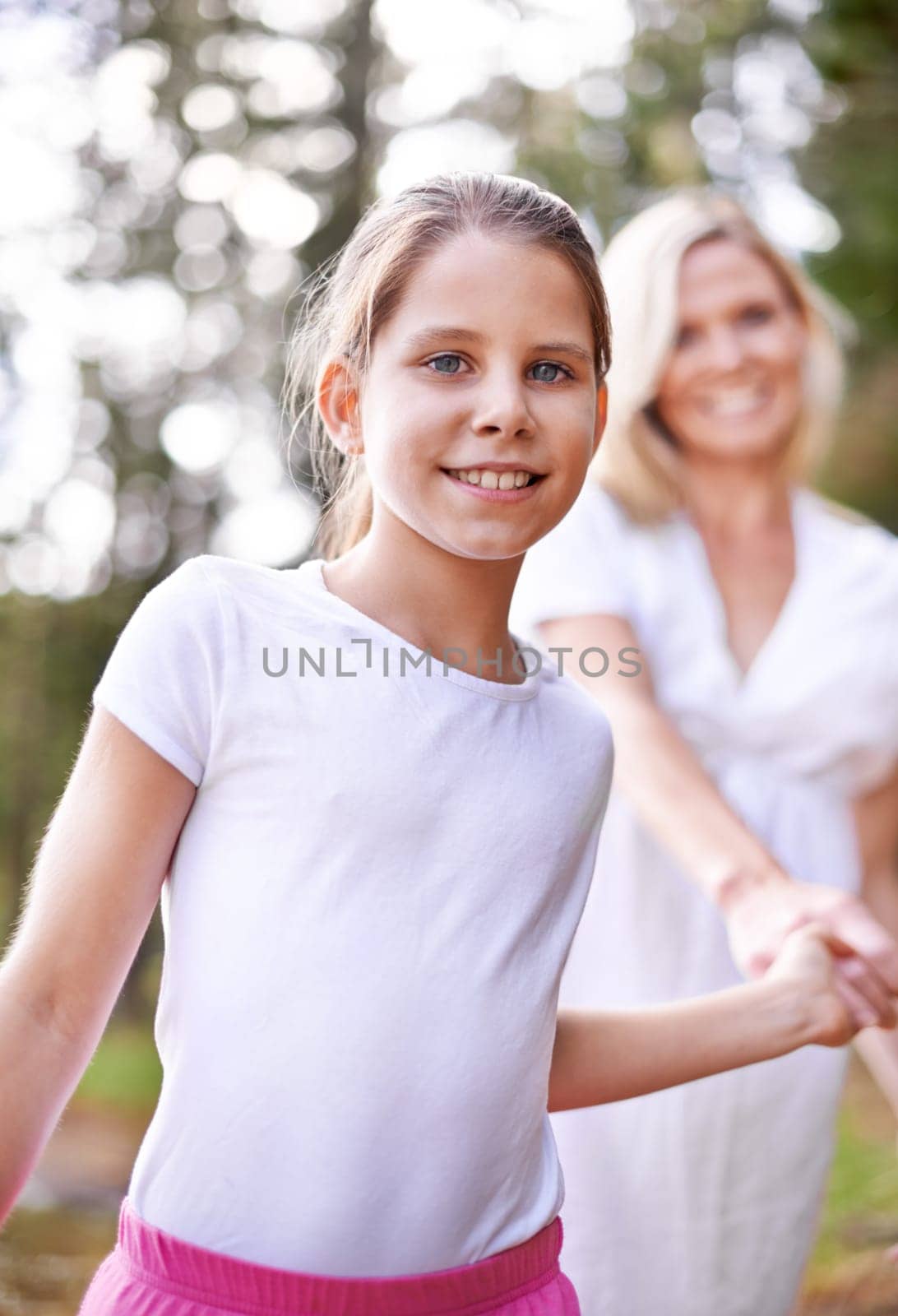Girl, child and portrait outdoor with happiness for bonding, support or holding hands with mother on holiday in nature. Family, woman or daughter with face, smile or trust on vacation, travel or love.