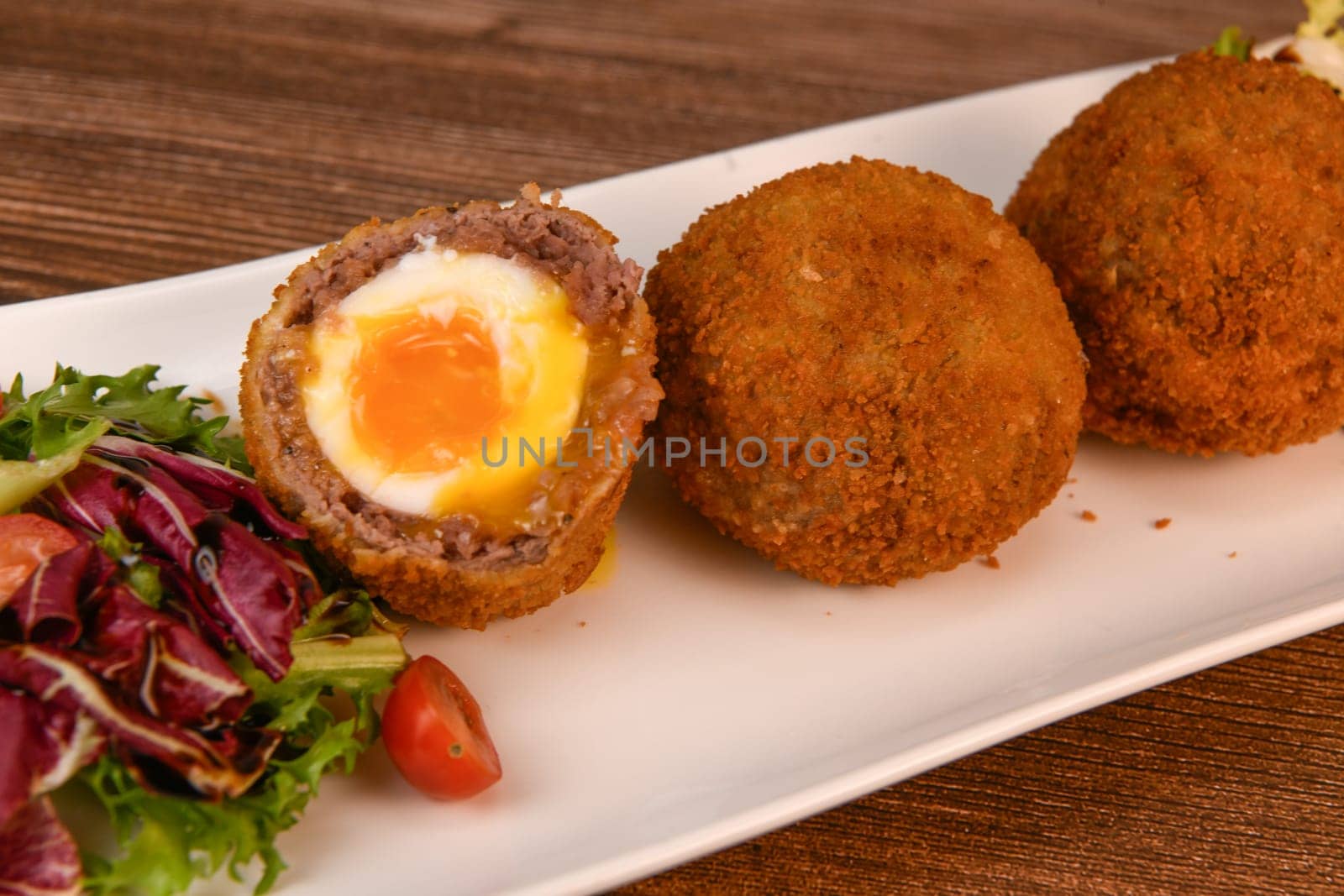 RECIPE FOR BREADED BEEF MEATBALLS STUFFED WITH A SOFT BOILED EGG. High quality photo