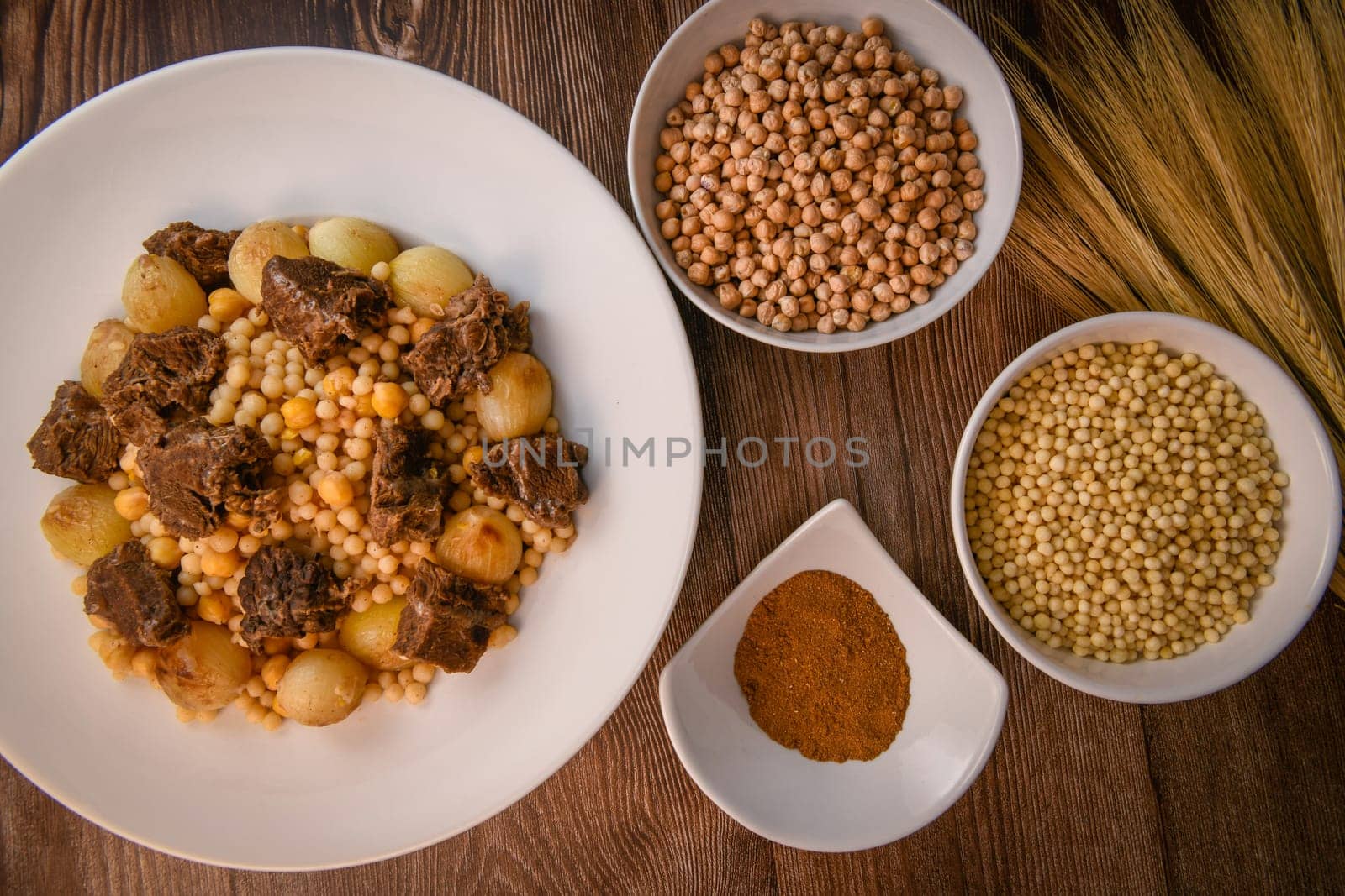 Moughrabieh is a popular dish in the Lebanese cuisine, LEBANESE RECIPE FOR MOUGHRABIEH WITH BEEF AND SMALL ONIONS, SEMOLINA PEARLS AND CHICKPEAS. High quality photo