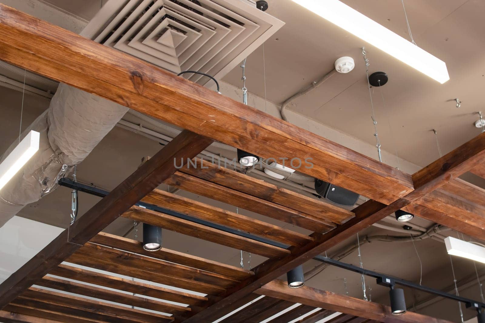 Wooden beams and air conditioning on the ceiling close up