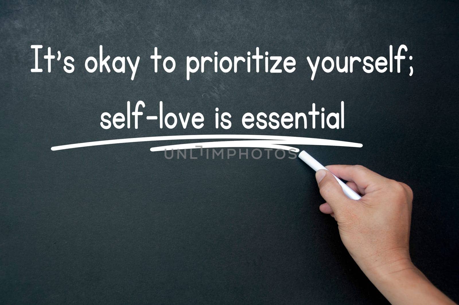 Hand writing It is okay to prioritize yourself affirmation on black board. Affirmation concept