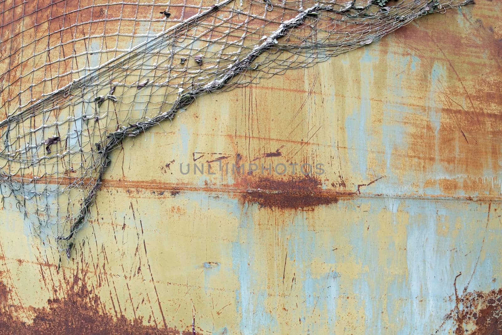 Background of rusty painted metal texture with old torn net on it
