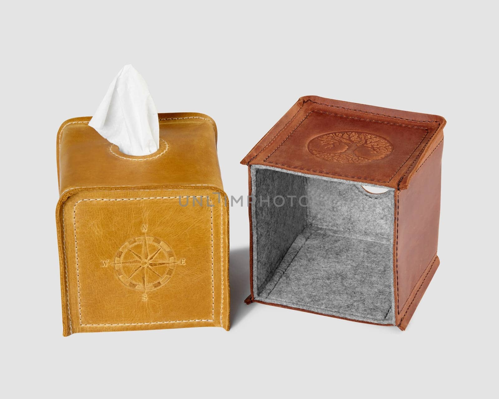 Stylish and convenient handcrafted natural leather tissue box covers with embossing and felt lining isolated on white background, perfect for home decor