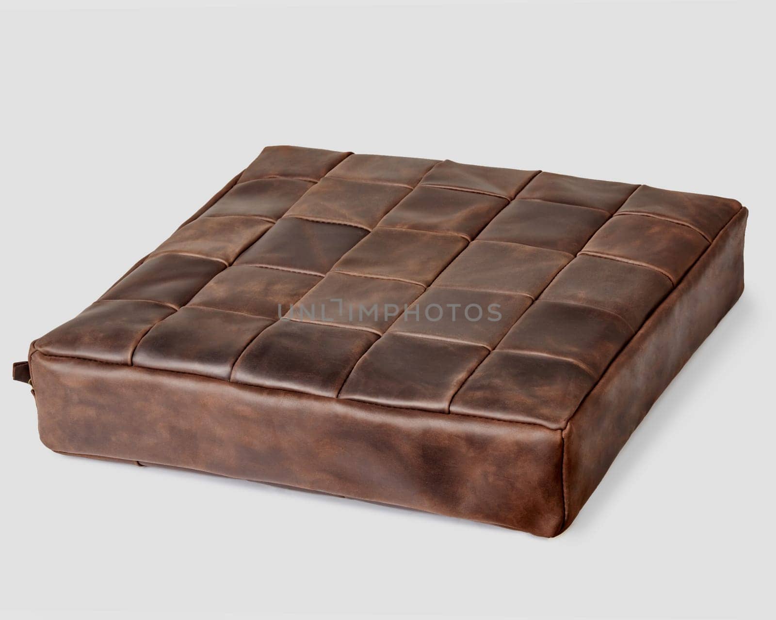 Decorative soft seat cushion upholstered by brown leather patches for comfort and stylish home interior design. Artisanal genuine leather products