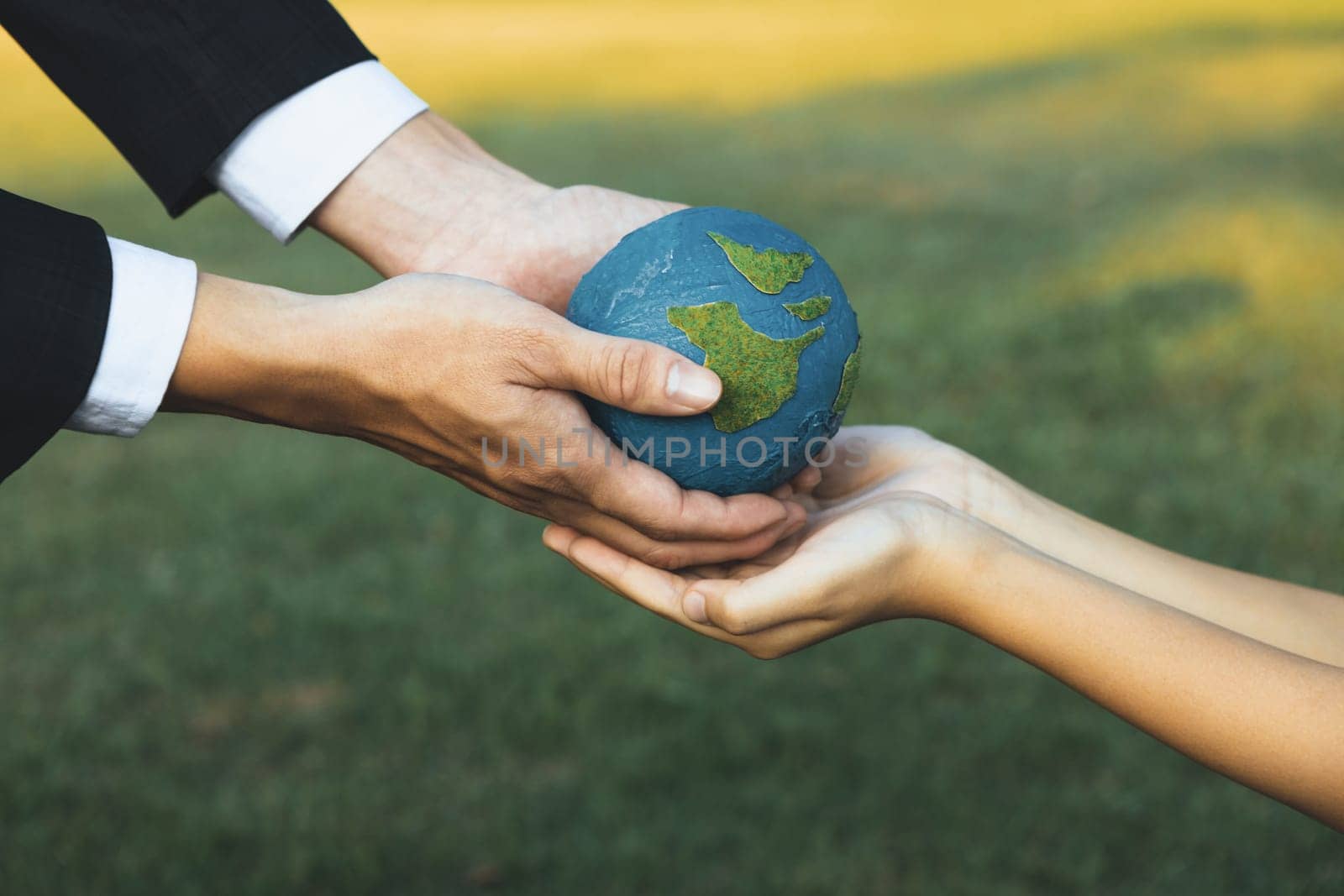 Businessman hand giving Earth globe to little boy as Earth day concept as corporate social responsible to contribute greener environmental protection for sustainable future generation. Gyre