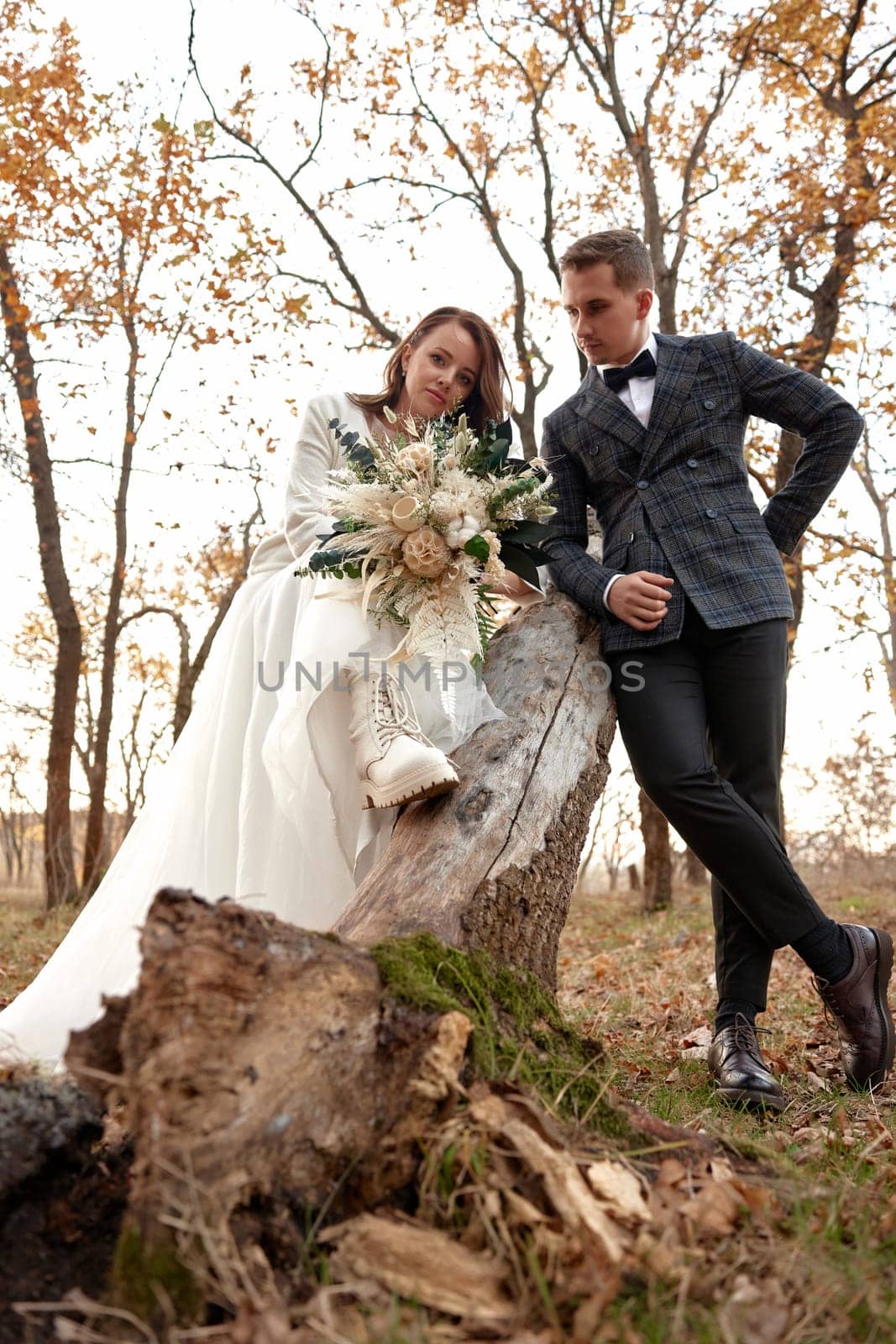 beautiful sensual bride in white wedding dress and groom standing outdoor on natural background