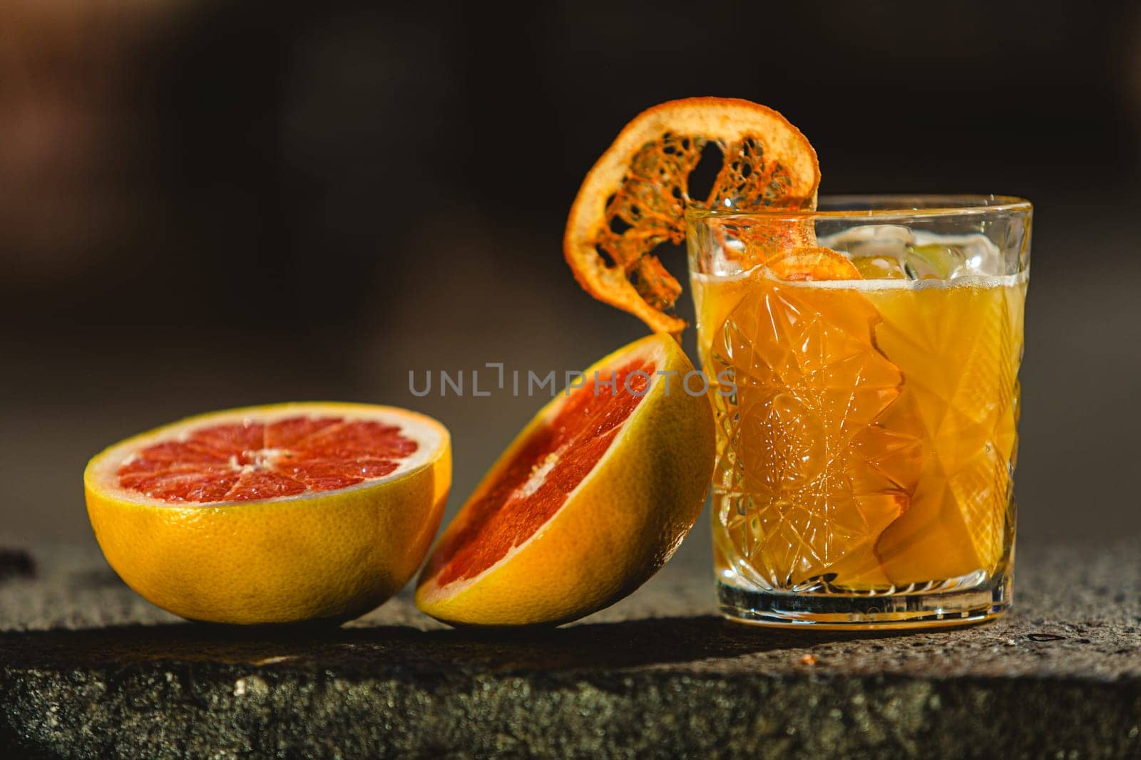 Delicious old fashion cocktail in the etched glass with ice and orange slices. Shallow dof. by sarymsakov