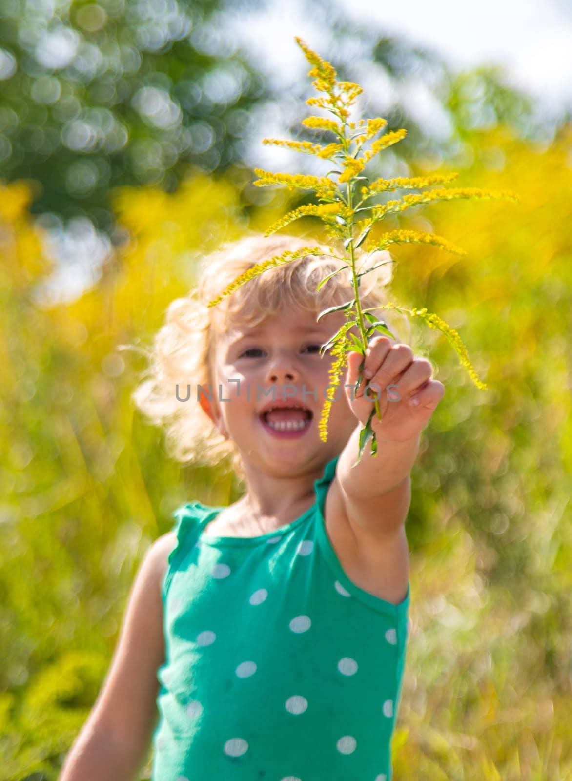 A child is allergic to ragweed blooming in the park. Selective focus. by yanadjana