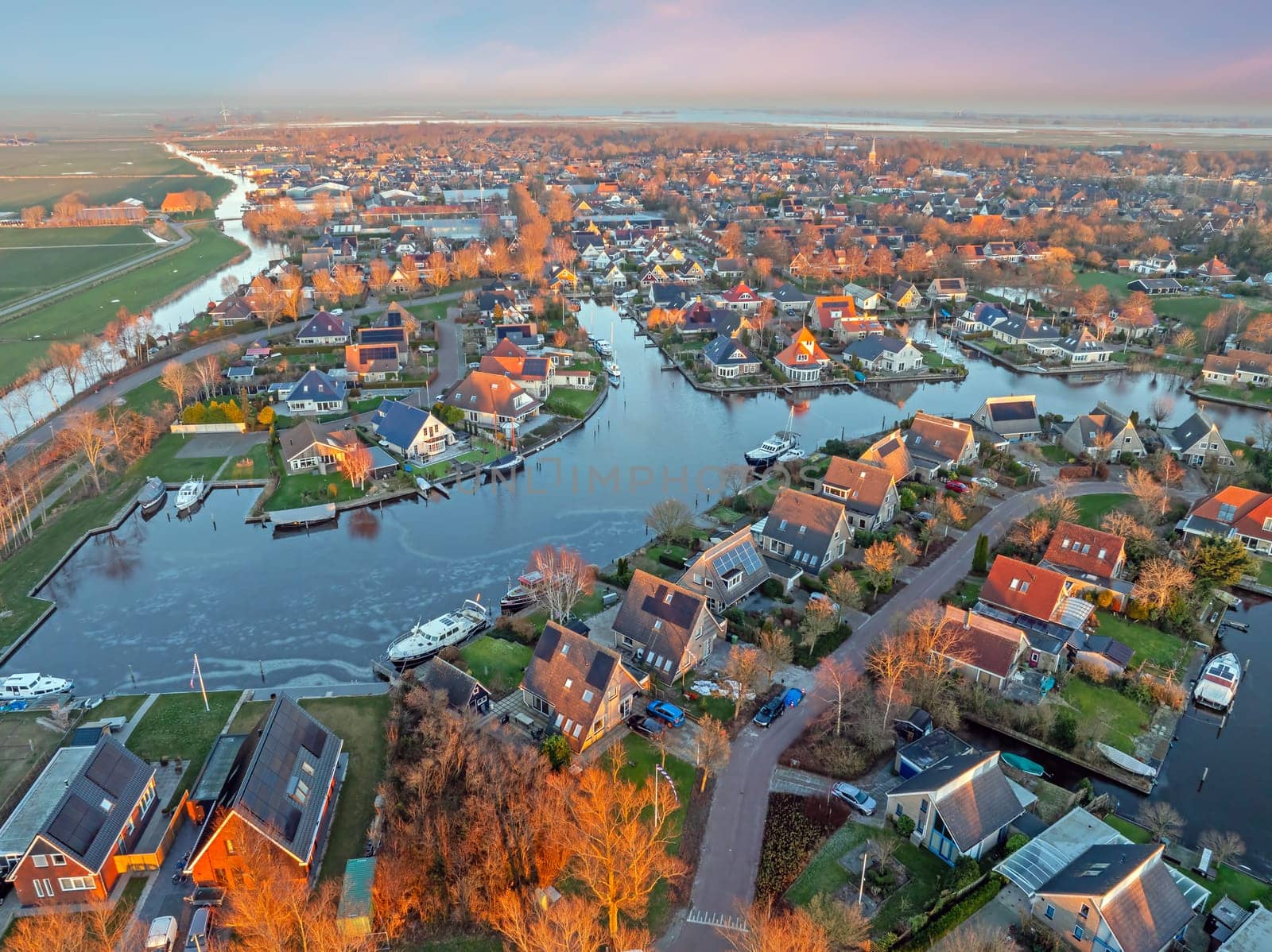 Aerial view on the traditional village Koudum in Friesland the Netherlands at sunset in winter