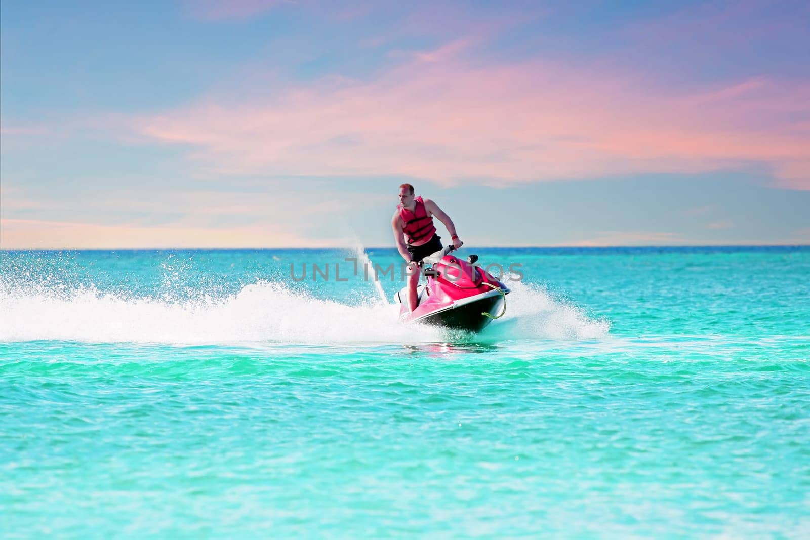 Young guy cruising on a jet ski on the caribbean sea