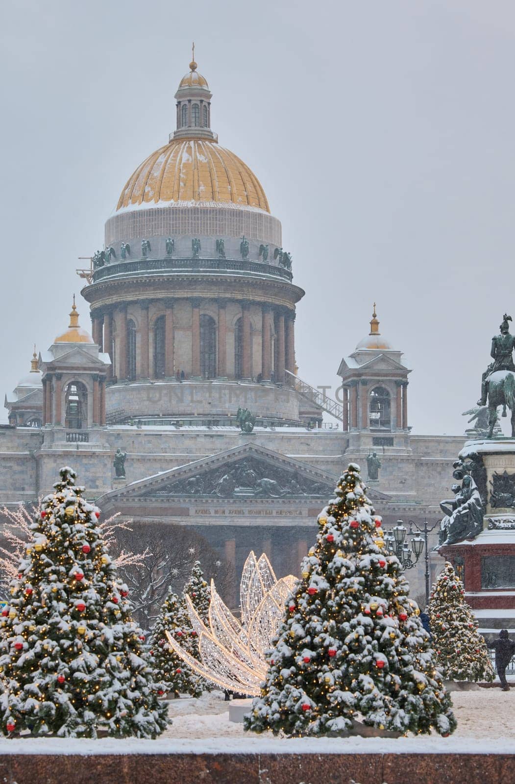 Russia, St Petersburg, St. Isaac's Cathedral and the monument to Emperor Nicholas II through lighting decorations during snowstorm, streets decorated for Christmas by vladimirdrozdin