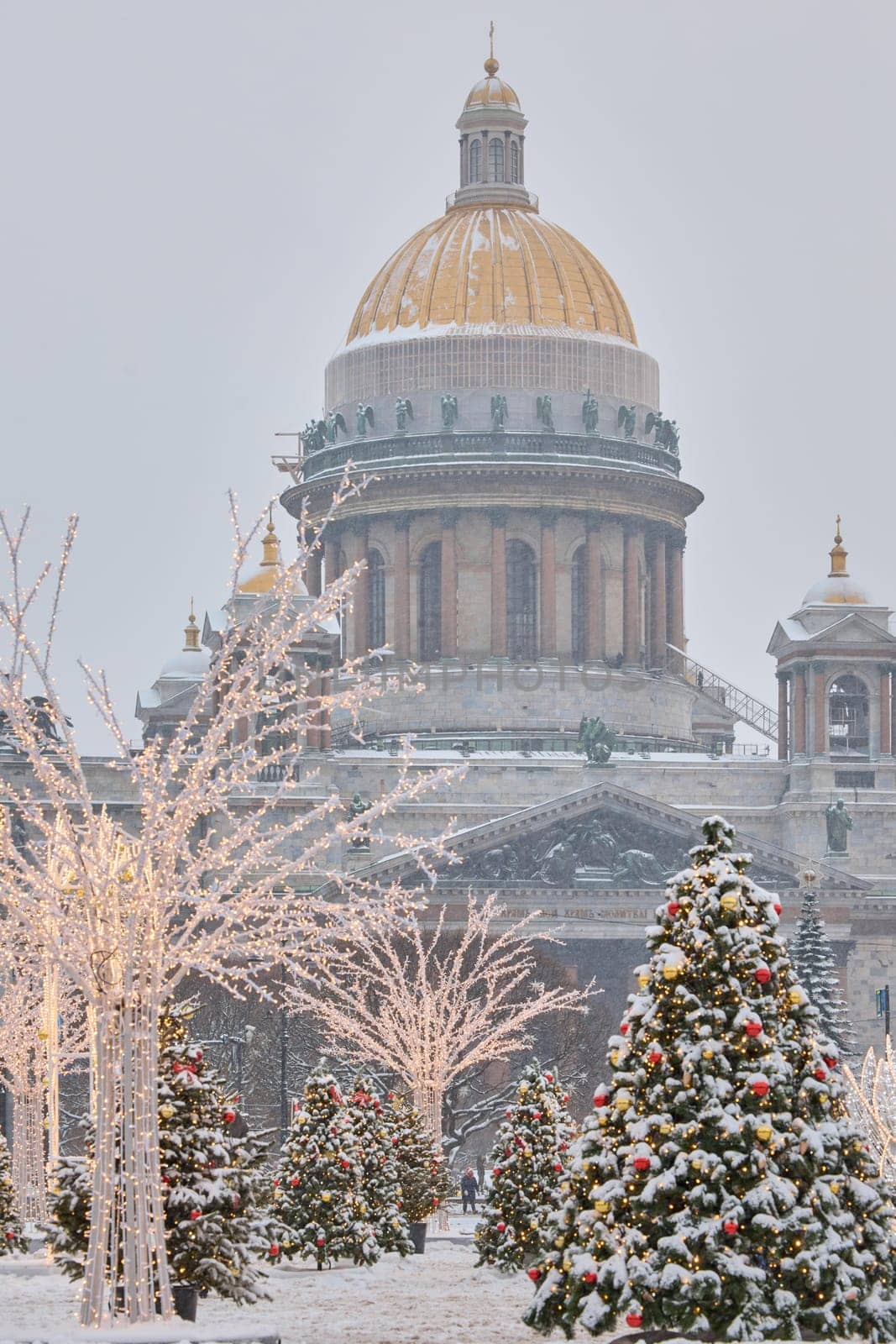 Russia, St Petersburg, St. Isaac's Cathedral and the monument to Emperor Nicholas II through lighting decorations during snowstorm, streets decorated for Christmas. High quality photo