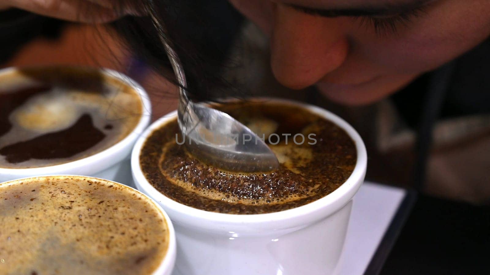 Professional barista tasting different types of coffee in cup tasters. Coffee degustation. by Peruphotoart