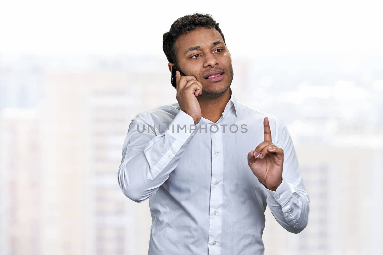 Portrait of confident young businessman talking on mobile phone. People, business, communication and modern technology concept.