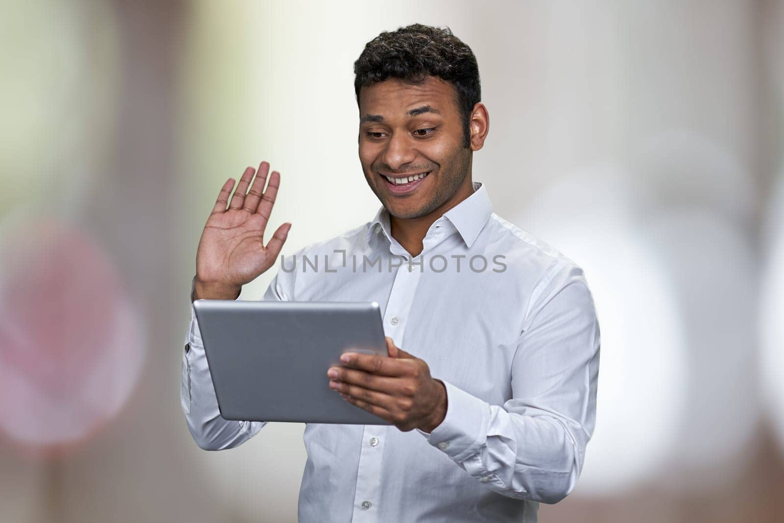 Happy young businessman waving while having video call on digital tablet. by super_picture
