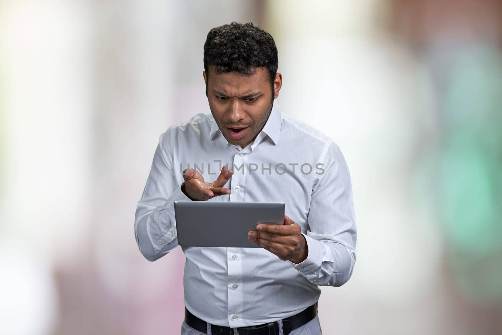 Shocked young businessman looking at digital tablet pc. by super_picture