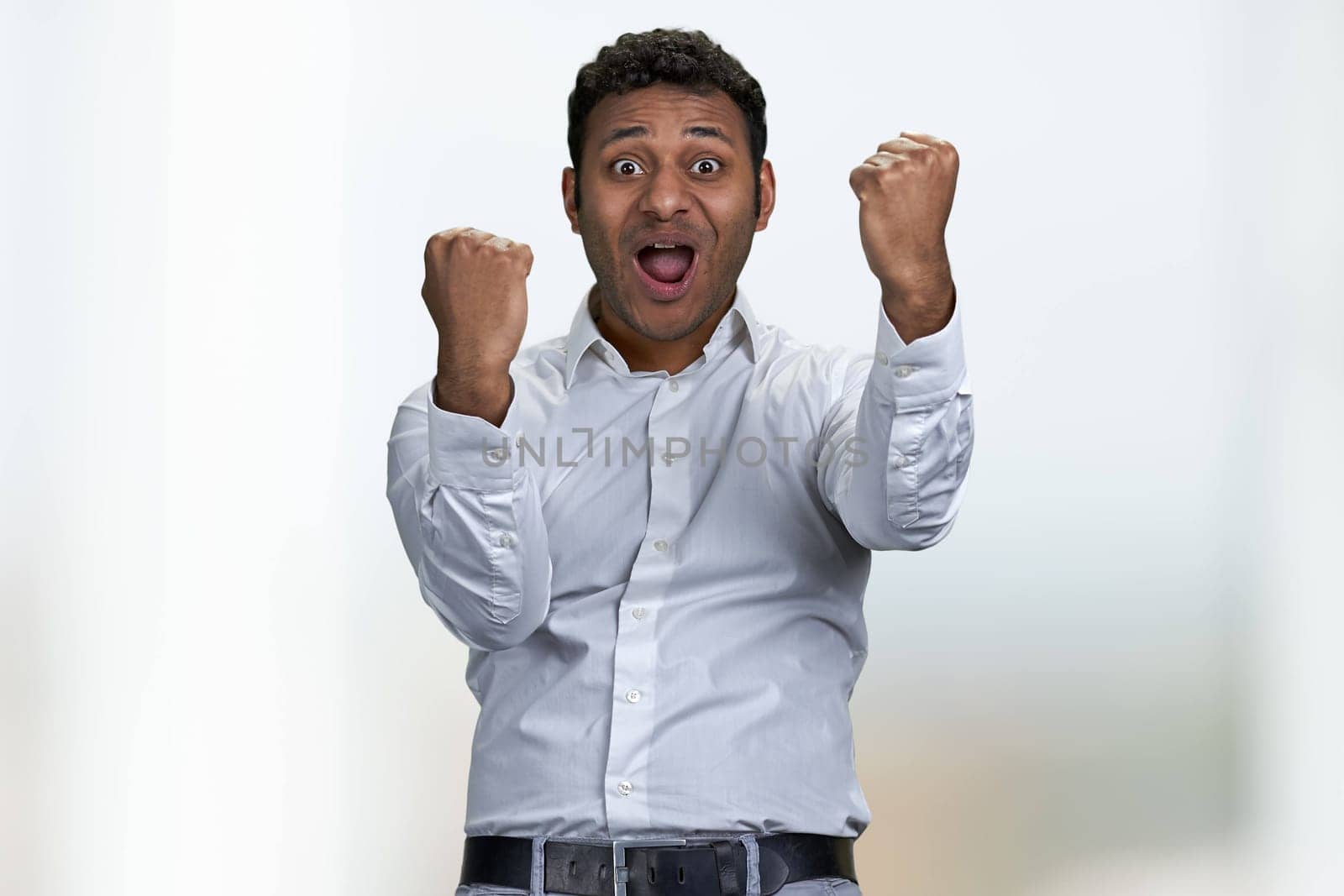 Excited businessman winner celebrating success with clenched fists. Business success concept.