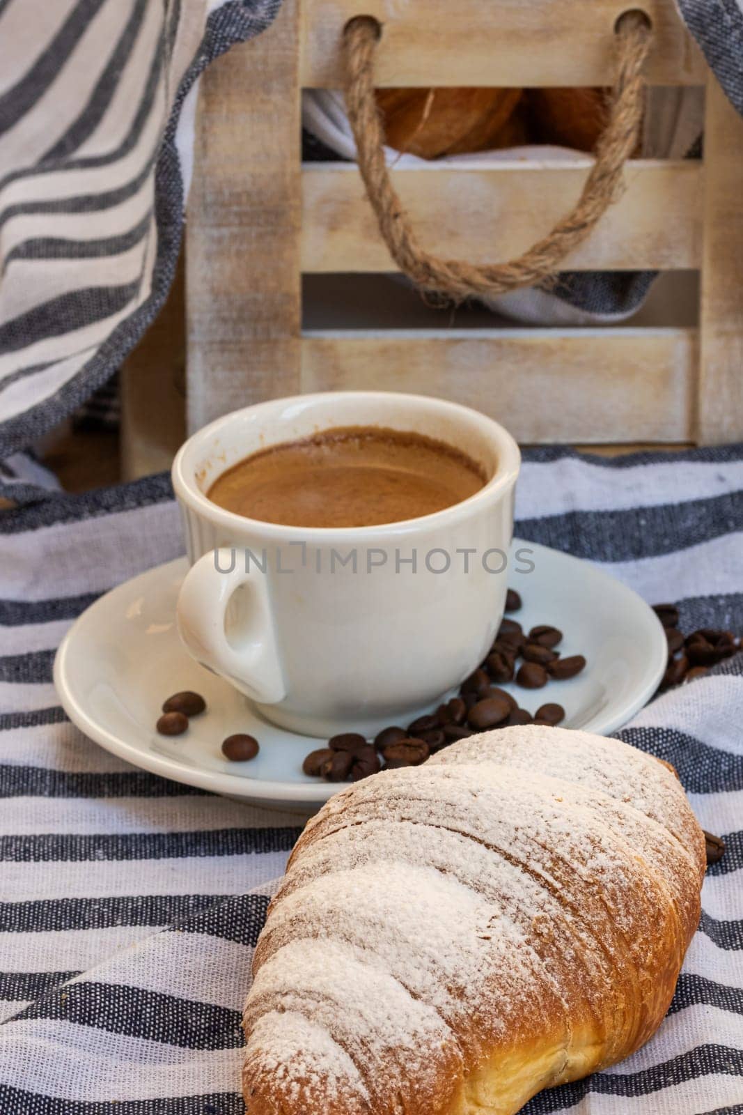 Puff pastry, coffee cup and buttered French croissant on wooden crate. Food and breakfast concept. Detail of coffee desserts and fresh pastries by vladispas