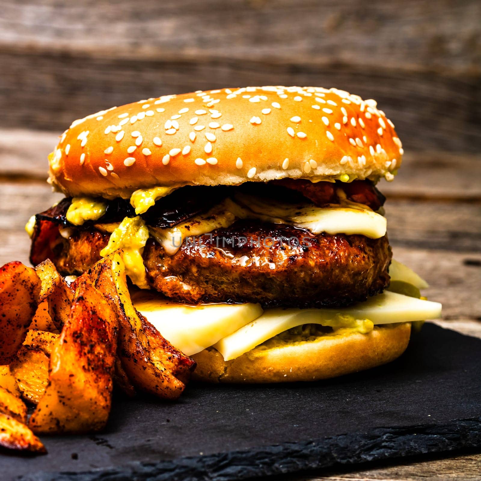 Tasty home made cheeseburger. Cheese burger with pickles, tomatoes, onion, melting cheese