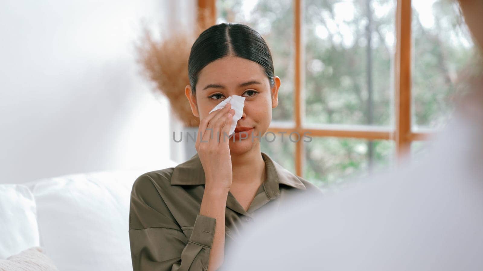 Sad PTSD woman patient in therapy for mental health with psychologist, depression or grief after life failure. Frustrated trauma young woman talking to vivancy psychologist about emotion in clinic
