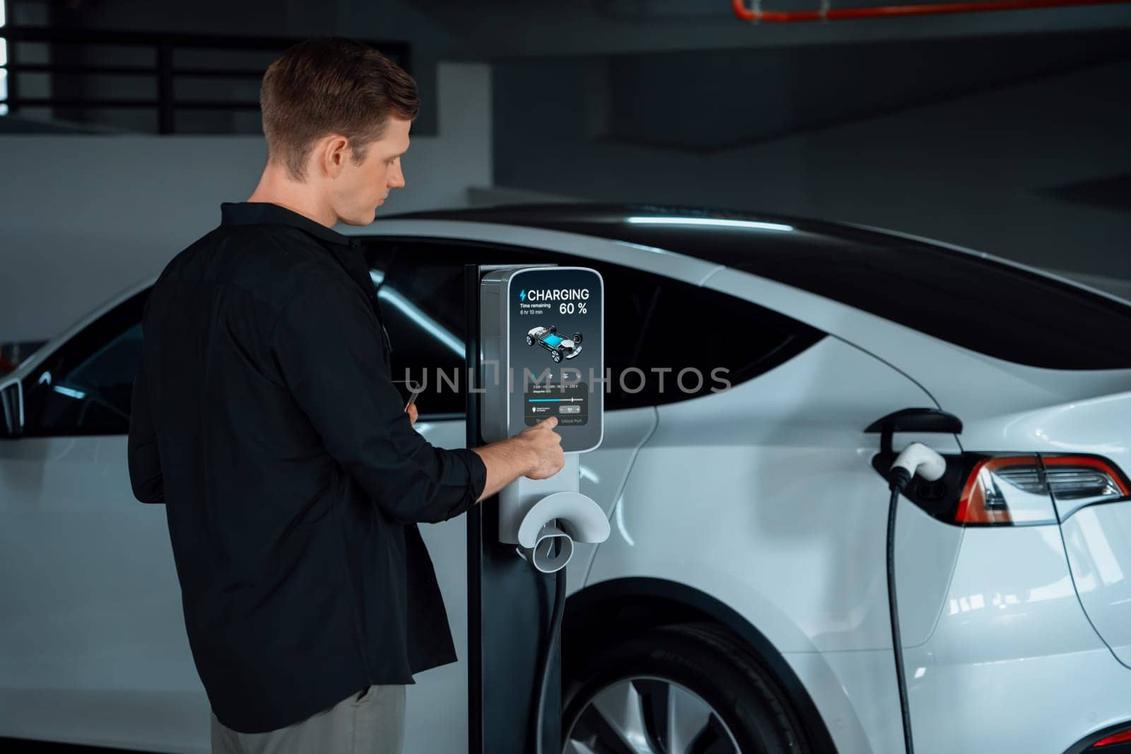 Young man travel with EV electric car to shopping center parking lot charging in downtown city showing urban sustainability lifestyle by green clean rechargeable energy of electric vehicle innards