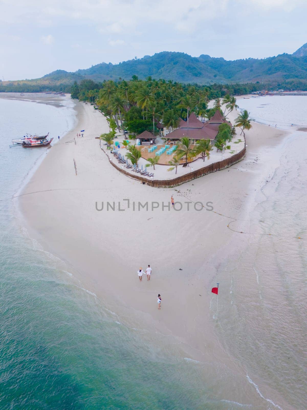 Drone aerial top view at Koh Muk a tropical island with palm trees and soft white sand, and a turqouse colored ocean in Koh Mook Trang Thailand
