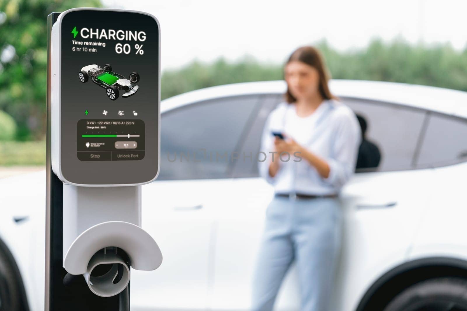 Young woman using smartphone to pay for electric car charging. Exalt by biancoblue