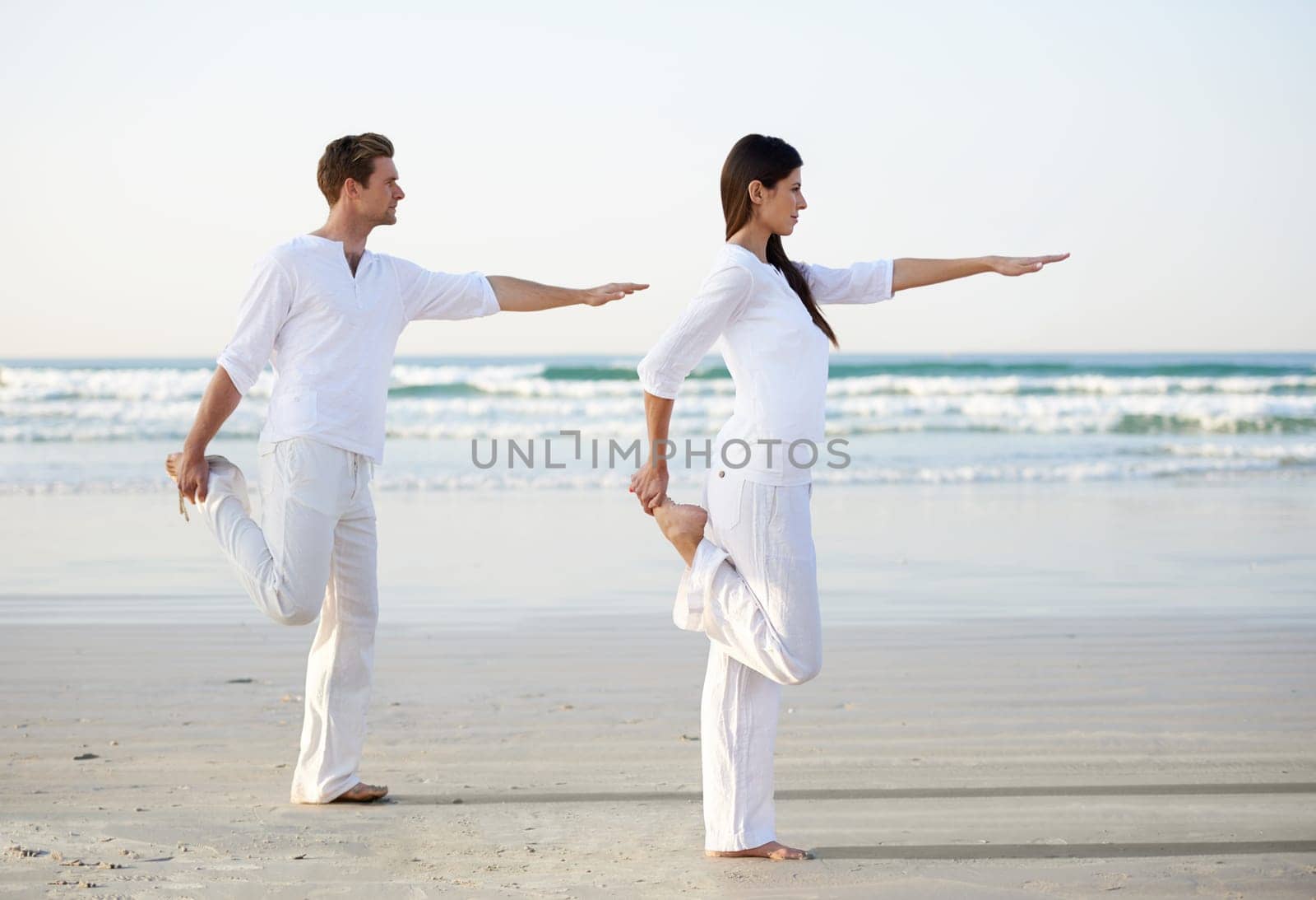 Couple, yoga and balance, fitness on beach for zen and wellness, travel and mindfulness with holistic healing. People outdoor, exercise and pose, workout together for bonding with ocean and nature by YuriArcurs