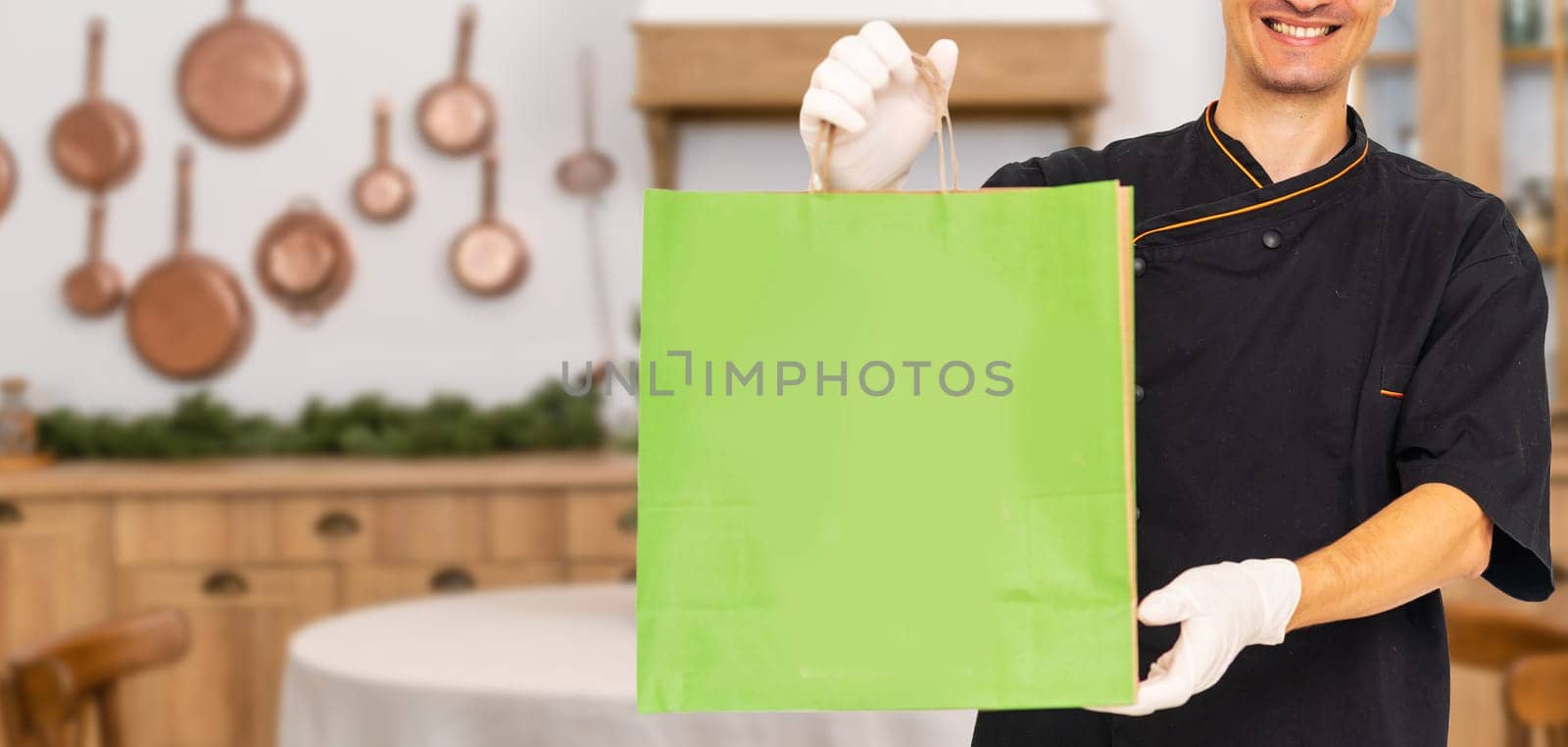 Young handsome man holding delivery paper bag by Andelov13