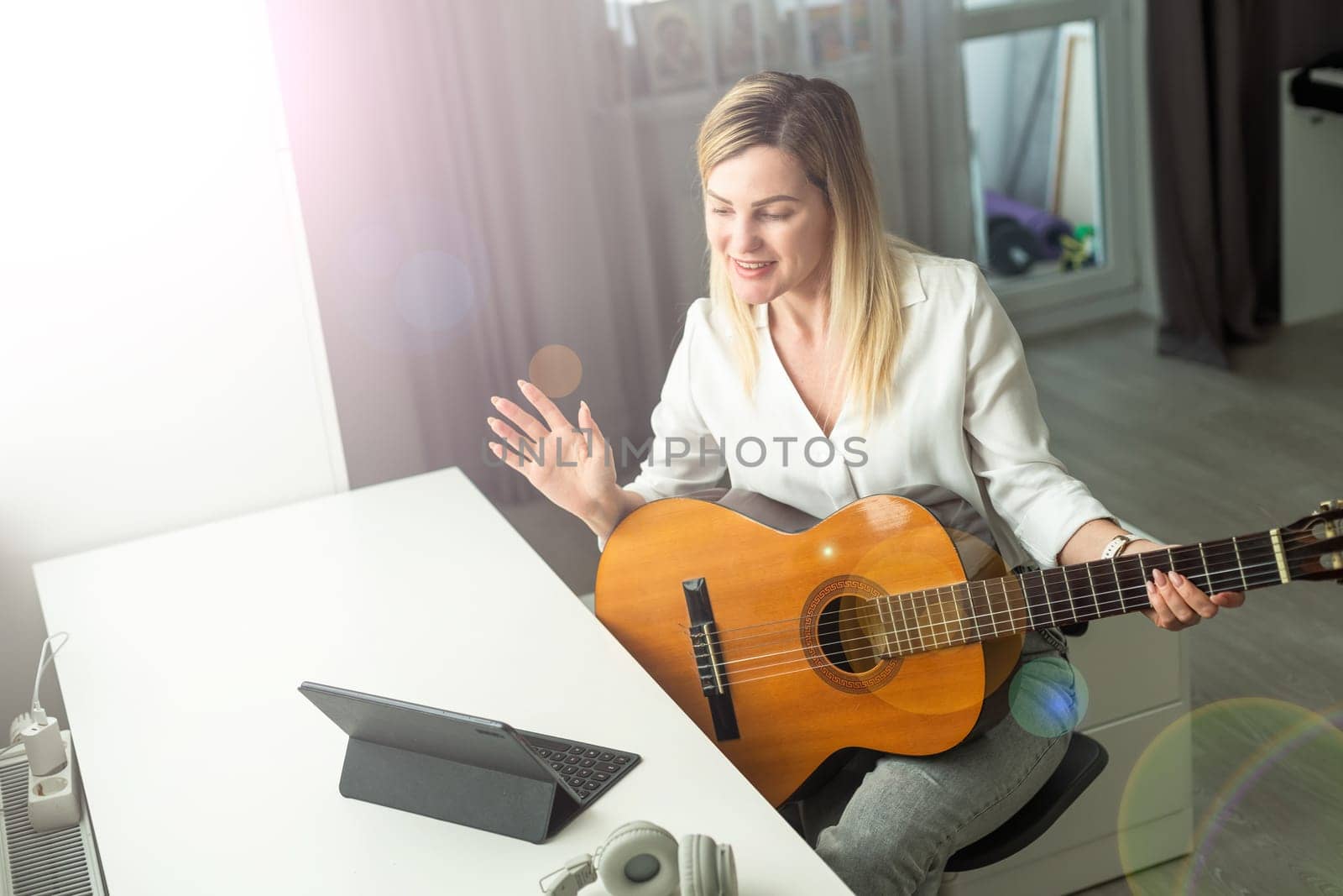 woman blogger live steam playing guitar on social media. High quality photo