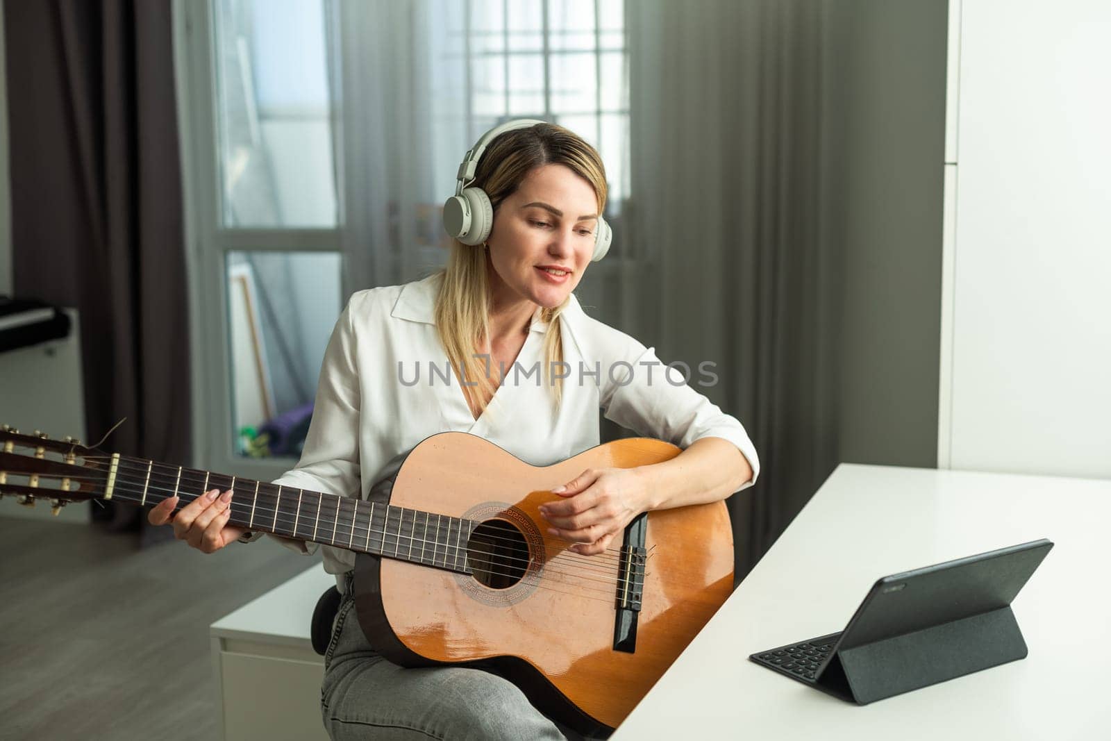 woman blogger live steam playing guitar on social media. High quality photo