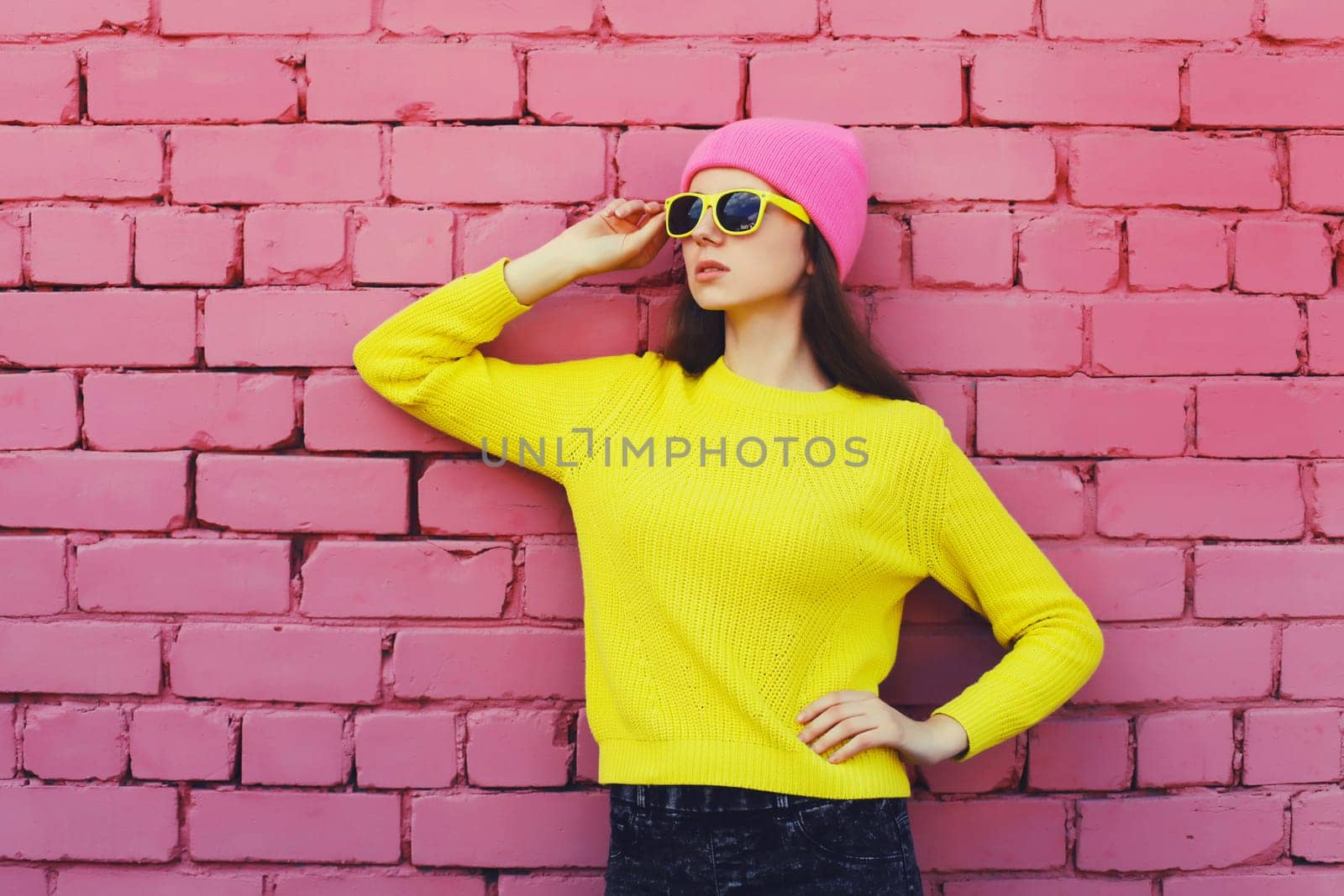 Portrait of stylish young teenager girl in colorful clothes, knitted yellow sweater pink hat by Rohappy