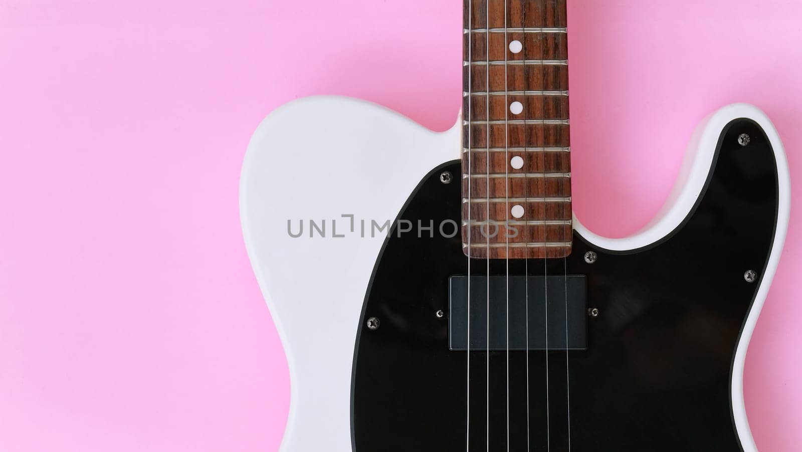 Black and white electric guitar on a pink background. by ponsulak