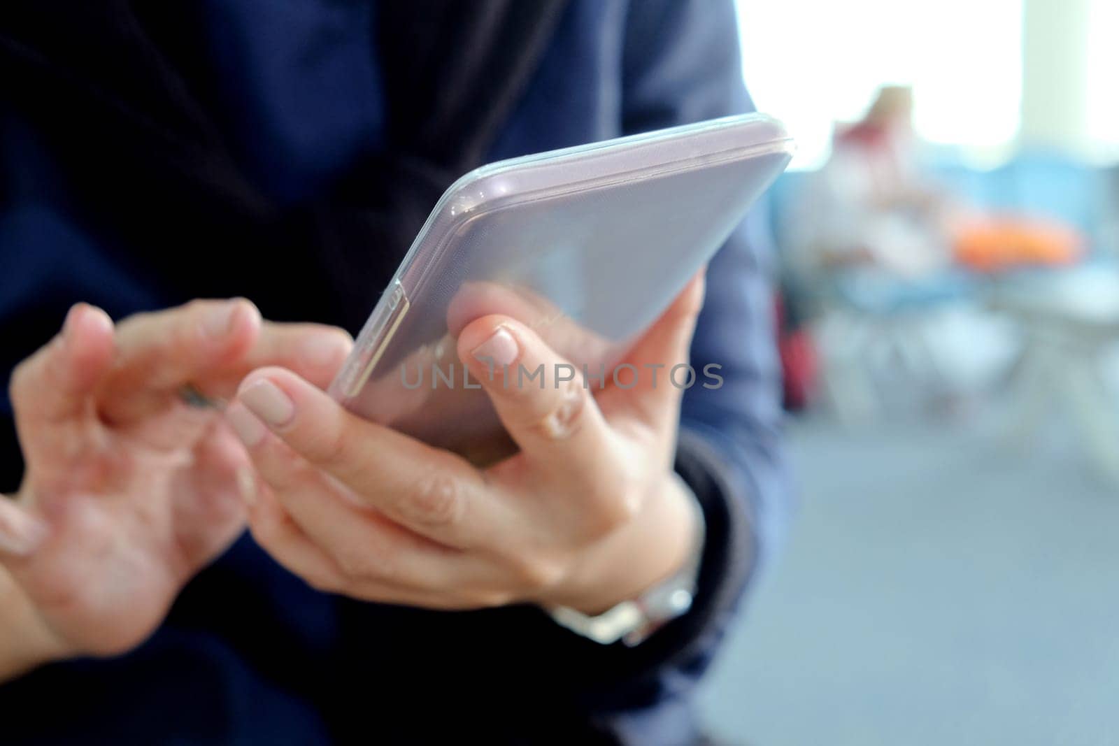 Close-up of a woman's hands holding and using a smartphone by ponsulak