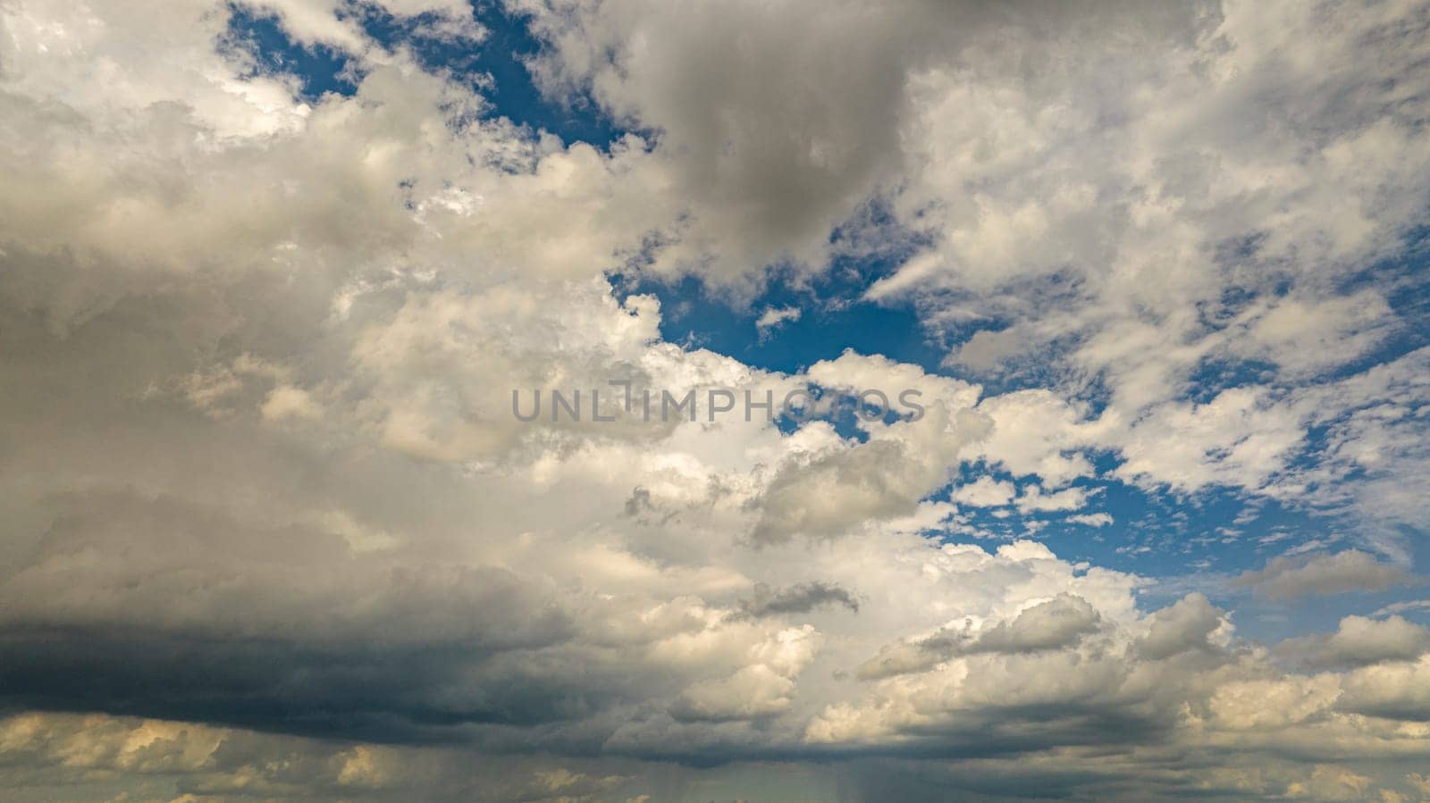 Expansive View Of A Blue Sky Filled With White Cumulus Clouds Casting Shadows On Each Other Under The Sunlight.